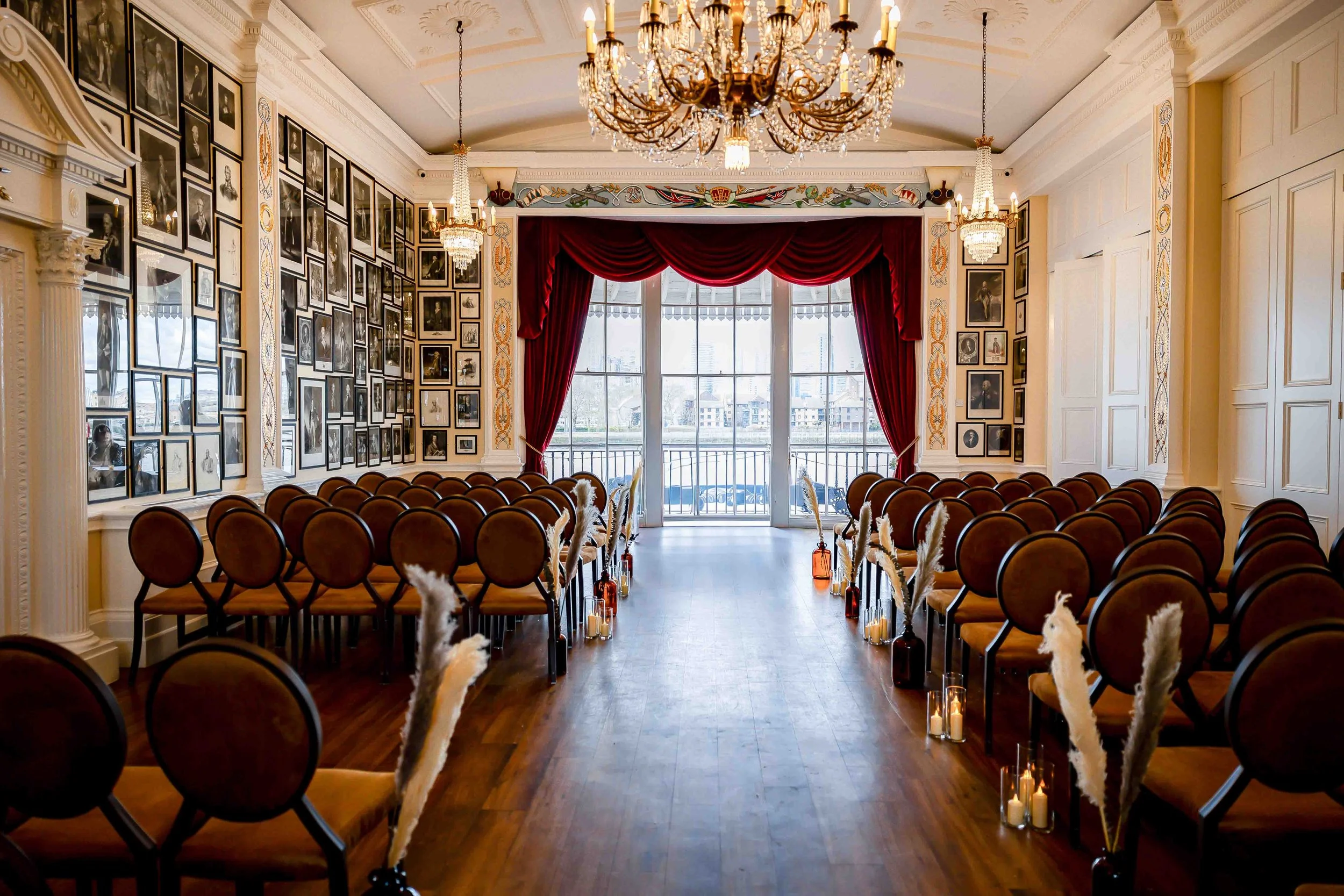Ceremony setup at Trafalgar Tavern wedding in Greenwich with chandeliers and red drapery
