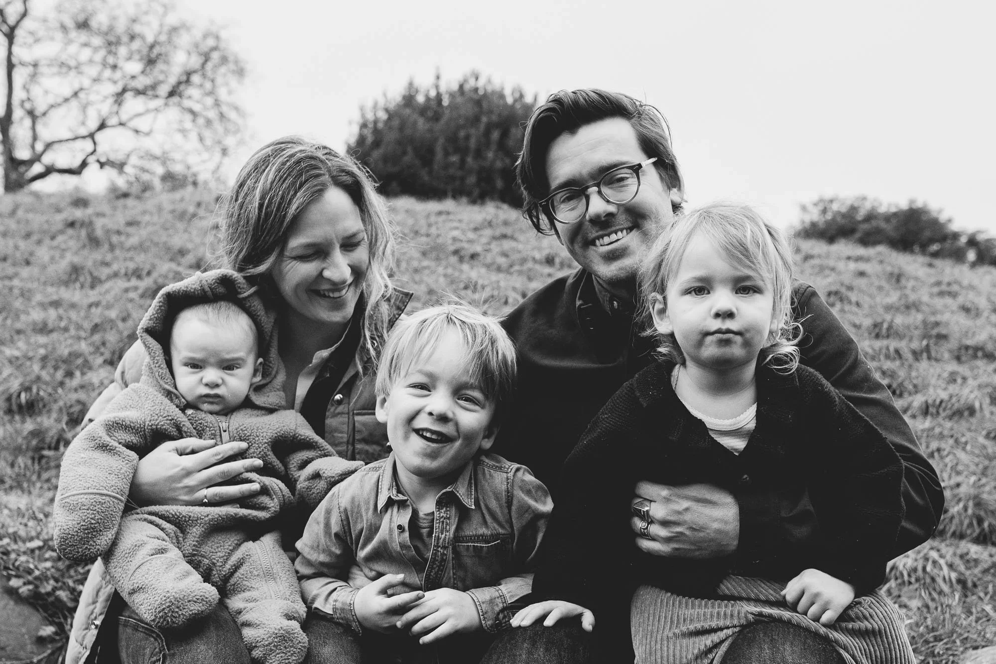 Award-winning family photography in Brighton and Hove, Sussex. Family of five posing in the park during an outdoor family photo session in Hove Park. Black and white family portrait.