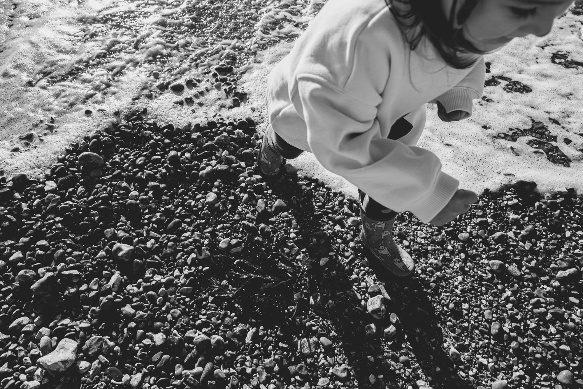 beach-photoshoot-brighton-family-photographer-girl-playing-in-sea-pebbles-portrait.jpg