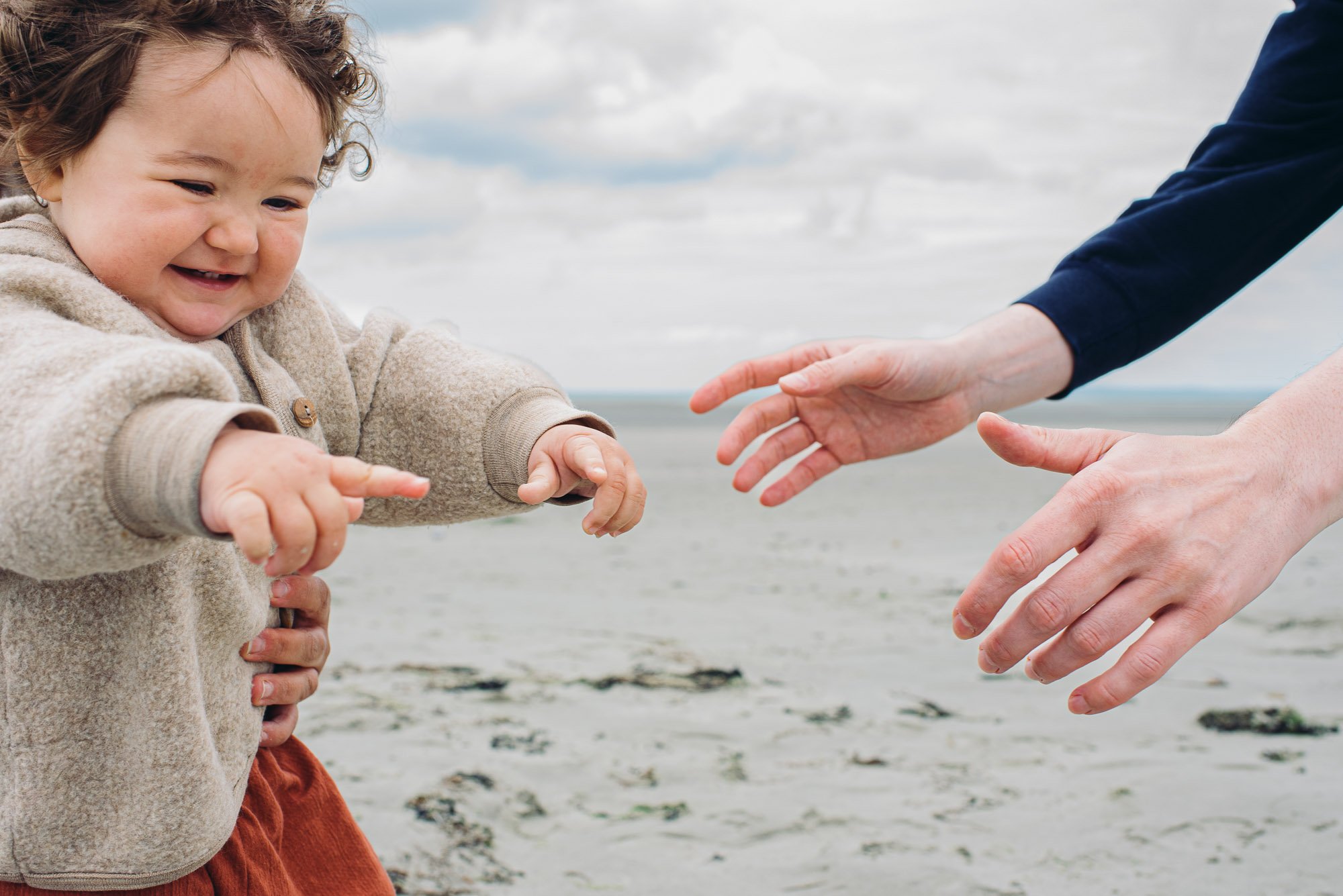 baby-girl-walking-towards-daddy-at-beach-west-wittering-west-sussex-chichester-family-photographer-natural.jpg