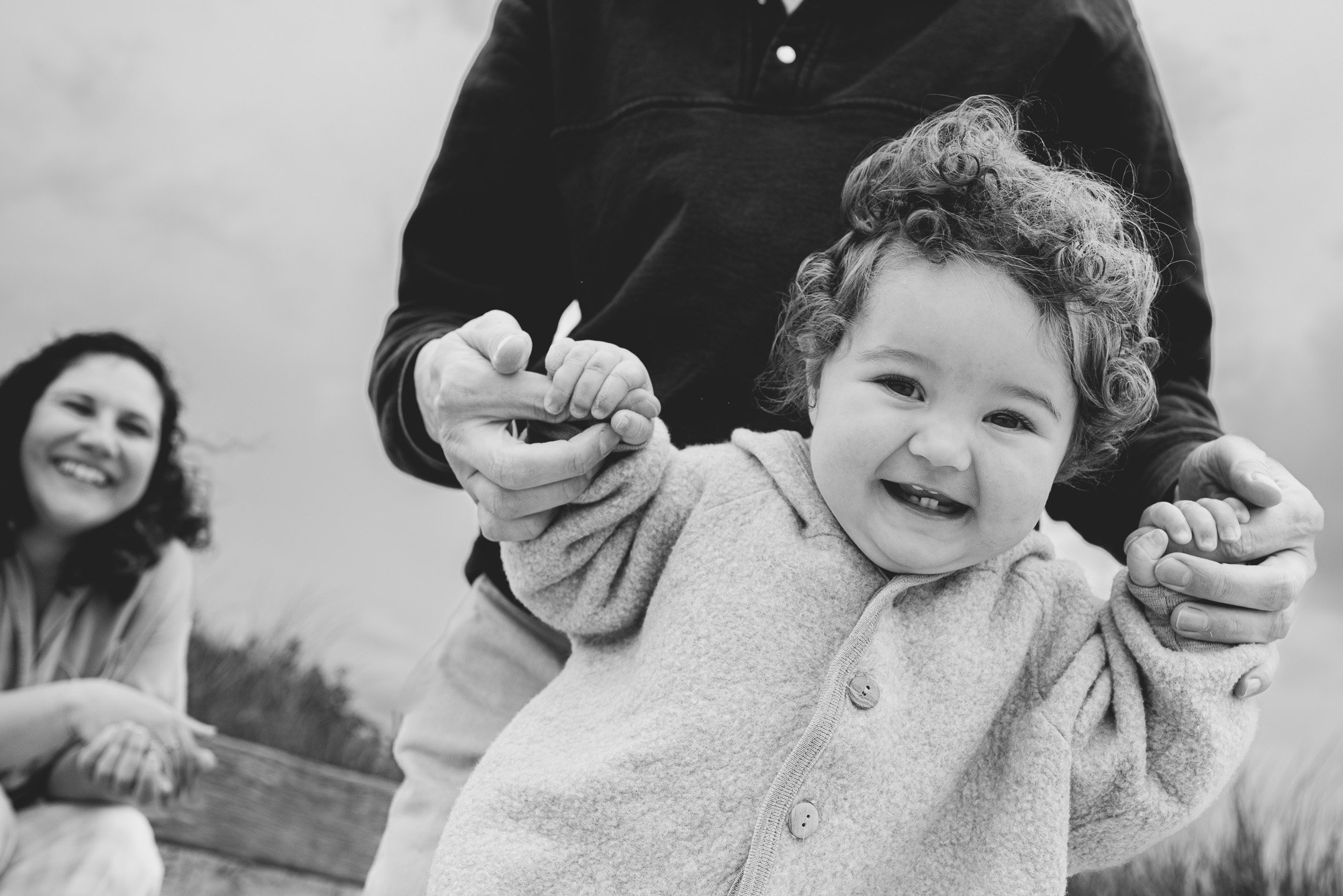 natural-family-portrait-black-and-white-girl-smiling-mum-in-background-chichester-family-photography-west-sussex.jpg