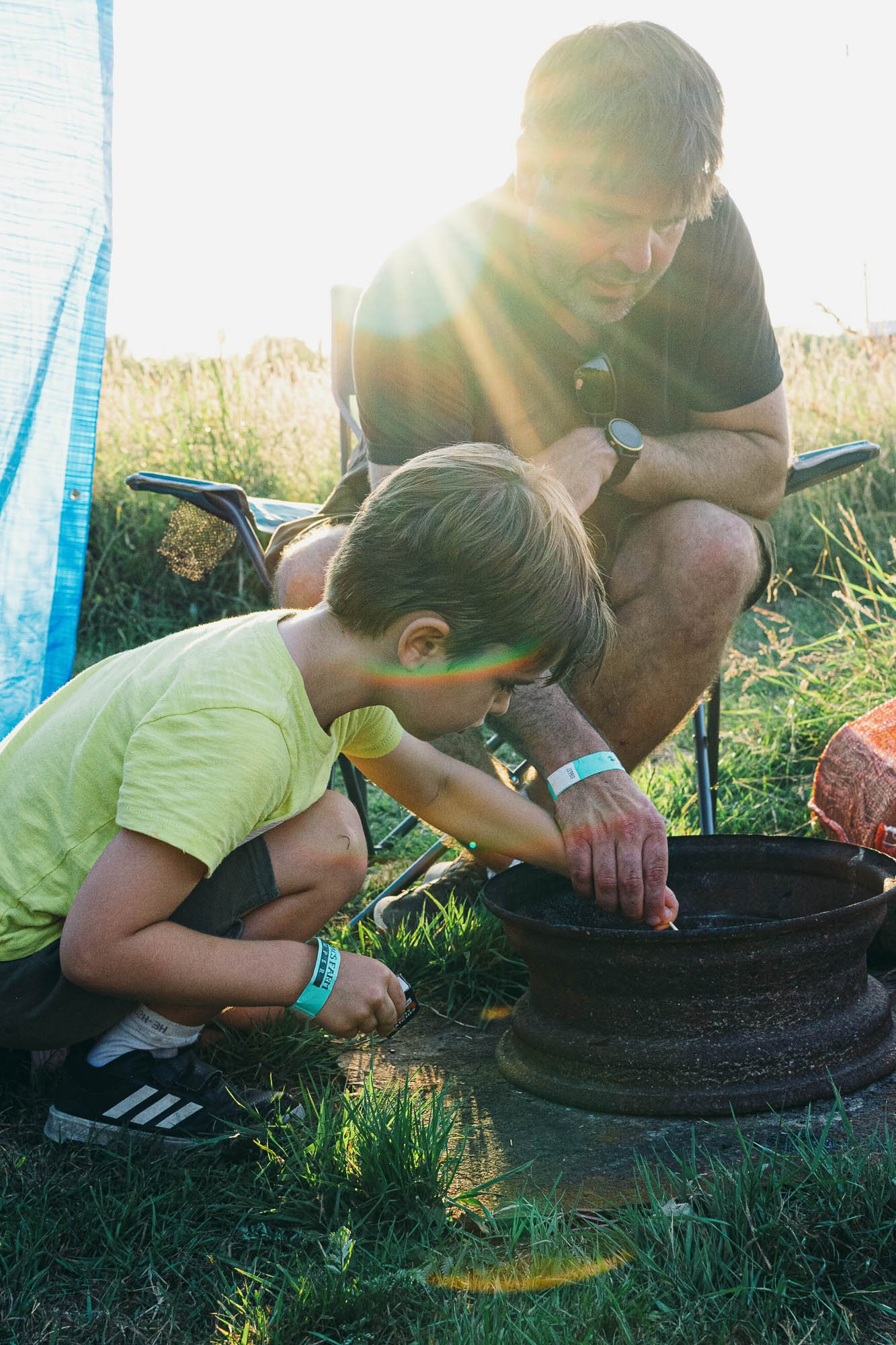 dad-and-son-building-camp-fire-family-photographer-sussex-unposed-natural-family-portraits-golden-hour-light.jpg