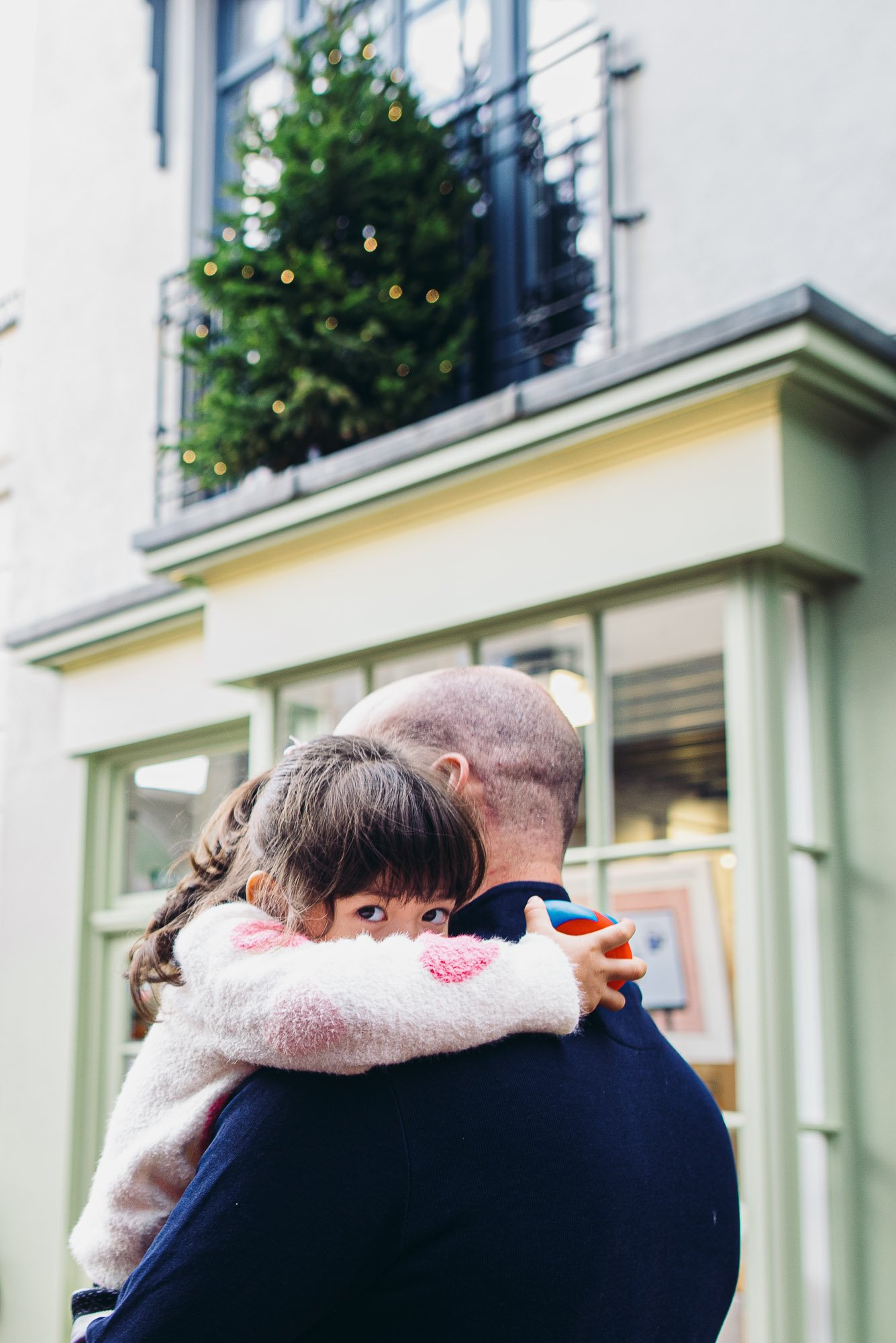 girl-being-carried-by-dad-during-family-photoshoot-brighton-hove-award-winning-family-photography-sussex.jpg
