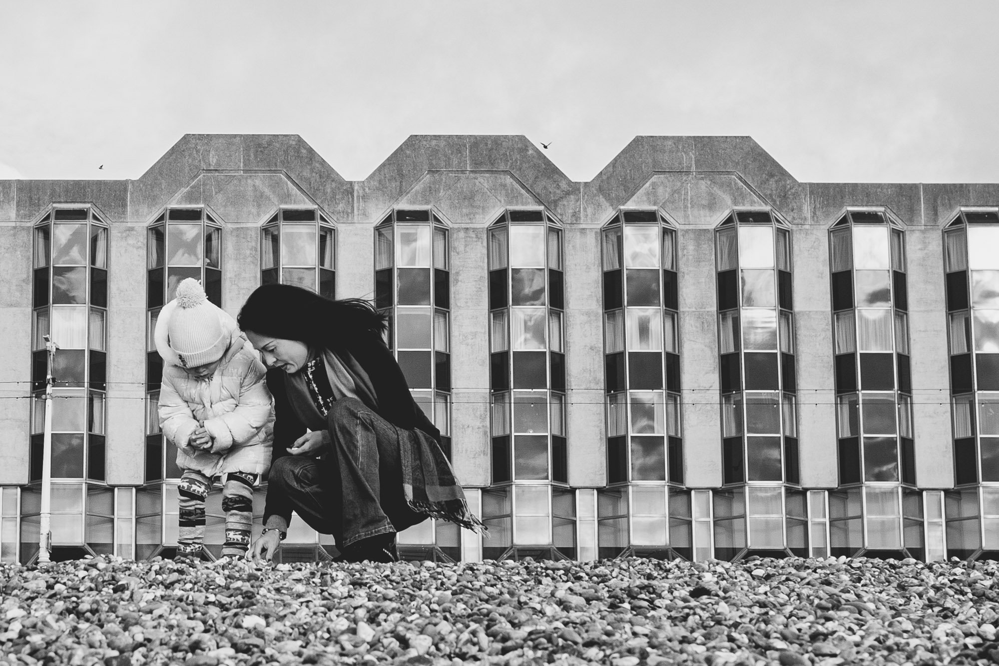 mother-daughter-brighton-beach-black-and-white-family-photo-collecting-stones-pebble-beach-brighton-hove-sussex.jpg