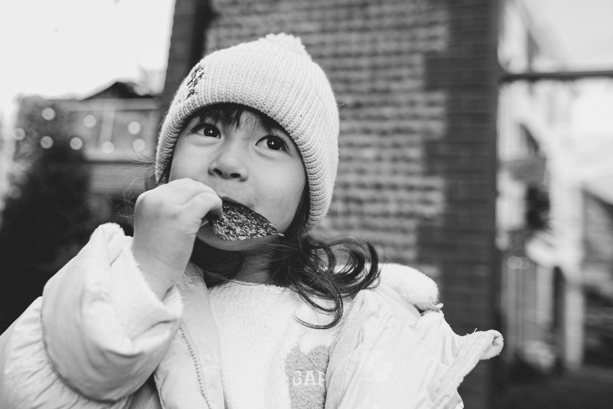 girl-eating-snack-seaweed-winter-day-documentary-family-photoshoot-brighton-hove-sussex-outdoor-family-photo-shoot.jpg