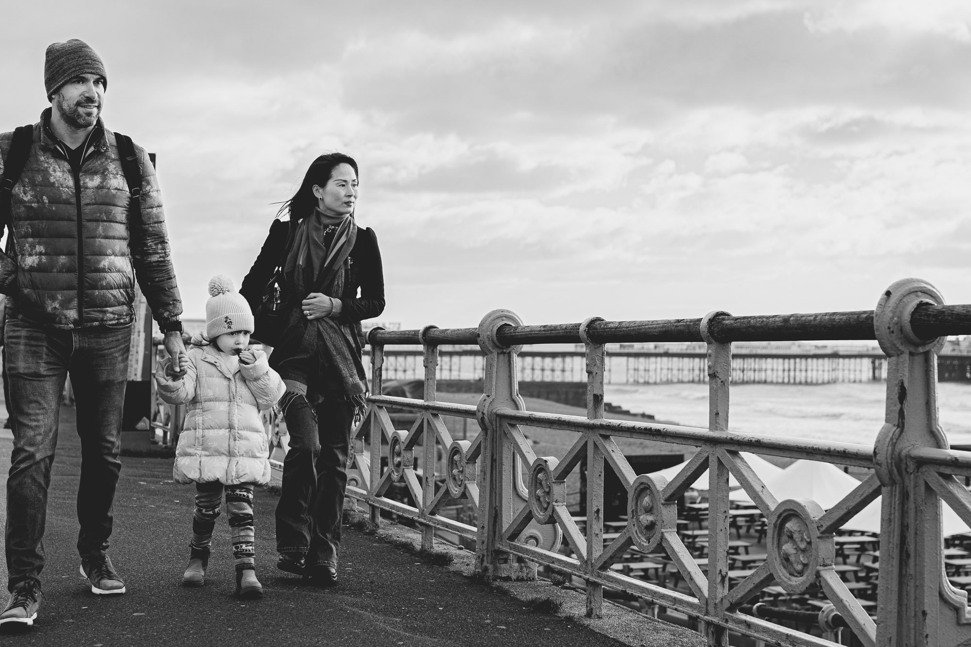 family-walking-to-brighton-beach-seafront-natural-family-photography-with-documentary-approach-sussex-family-photographer-pier-background.jpg