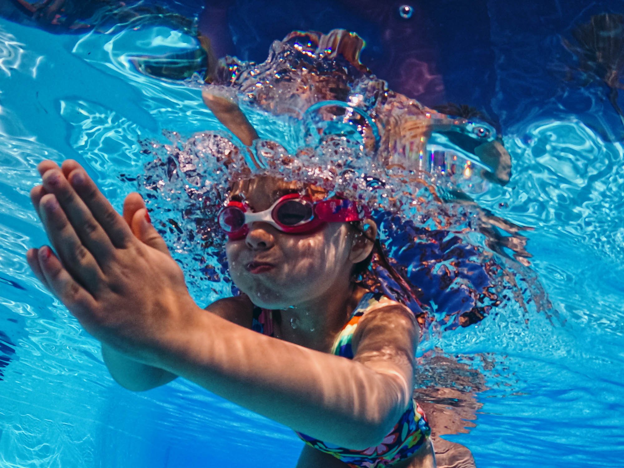girl-swimming-underwater-pool-goggles-underwater-portrait-unposed-family-holiday-photography.jpg