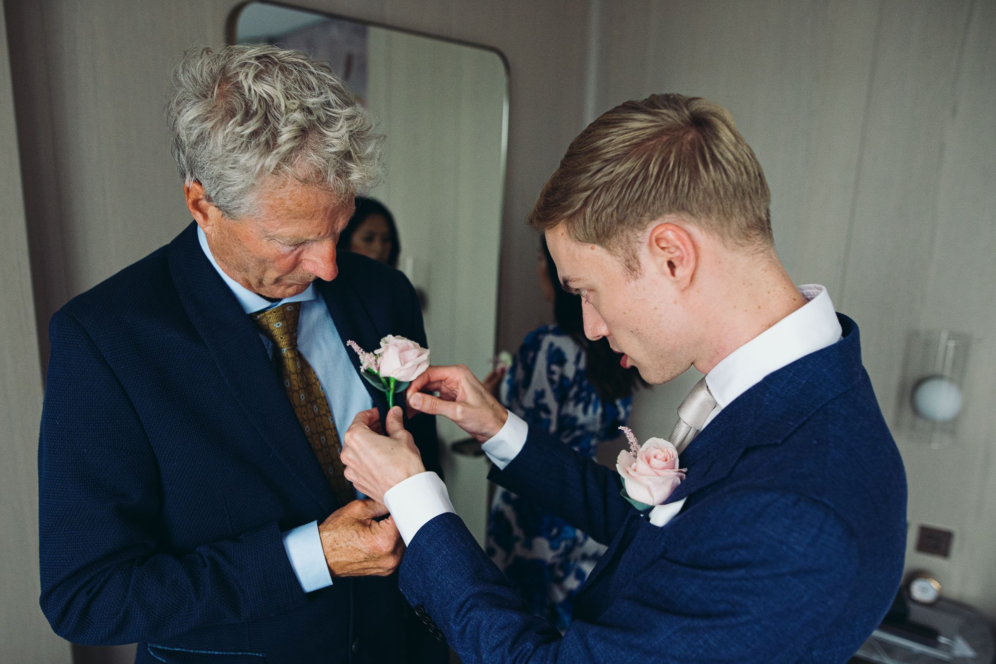 dad-groom-corsage-buttenholes-documentary-wedding-photography-brighton-getting-ready-in-hotel-room.jpg