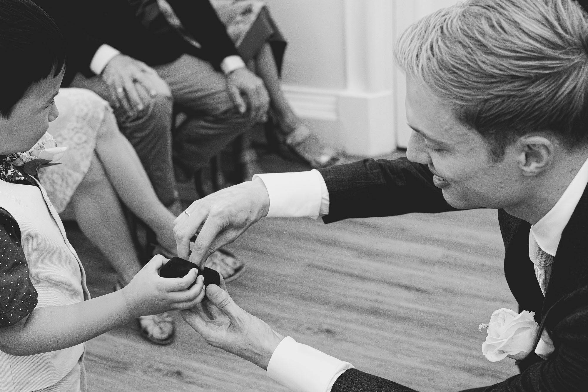 wedding-rings-groom-getting-ring-from-ring-bearer-black-and-white-wedding-photos.jpg