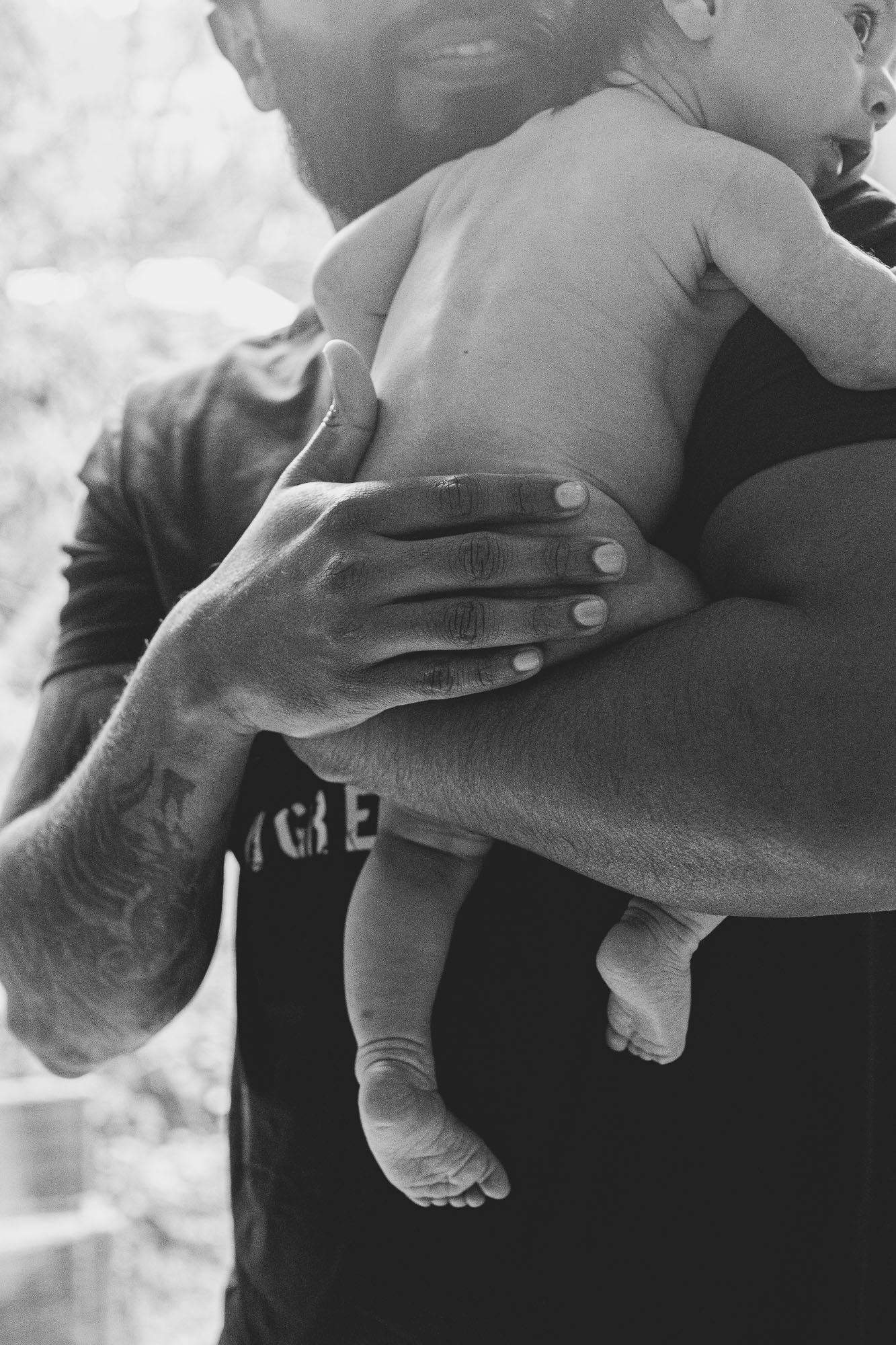brighton-newborn-photographer-hove-preston-park-newborn-photo-shoot-at-home-black-and-white-natural-dad-holding-baby-girl.jpg