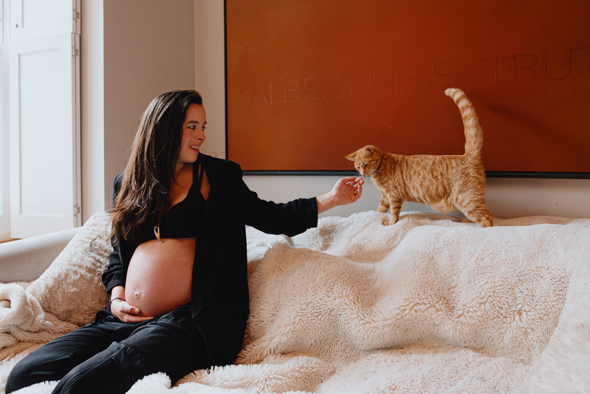 Wimbledon maternity photographer capturing pregnant woman and cat at home.