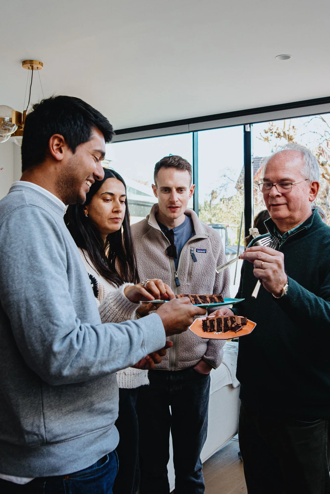 Family eating birthday cake at home during birthday party celebrations in Twickenham, South West London.