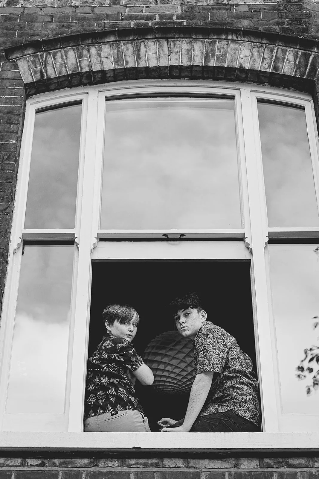 brothers-posing-sitting-window-at-home-family-photoshoot-balck-and-white.jpg
