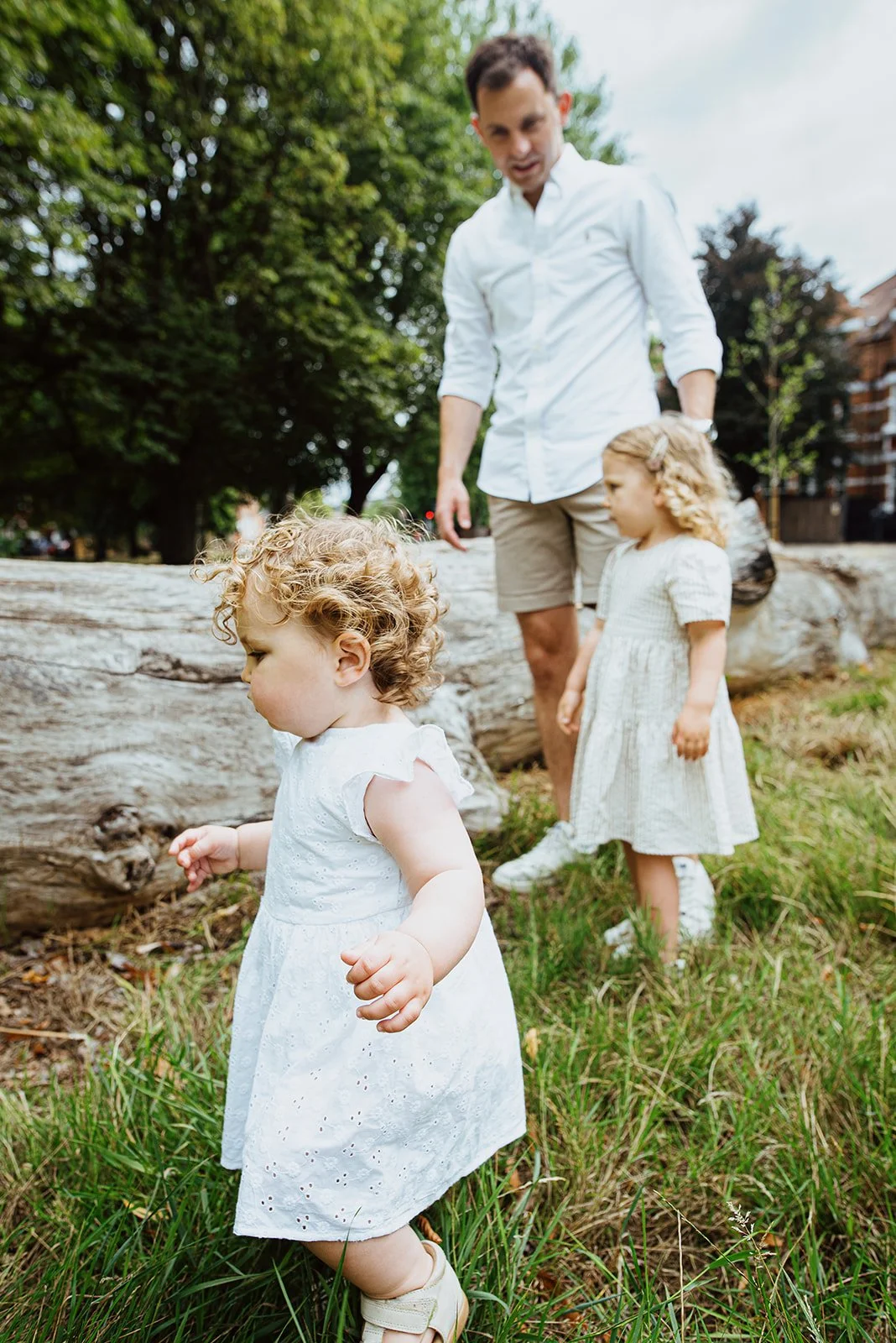 Hampstead Heath family photoshoot, dad and his two daughter playing in the park. Natural lifestyle family photography in Highgate, Hampstead Heath and across North London.