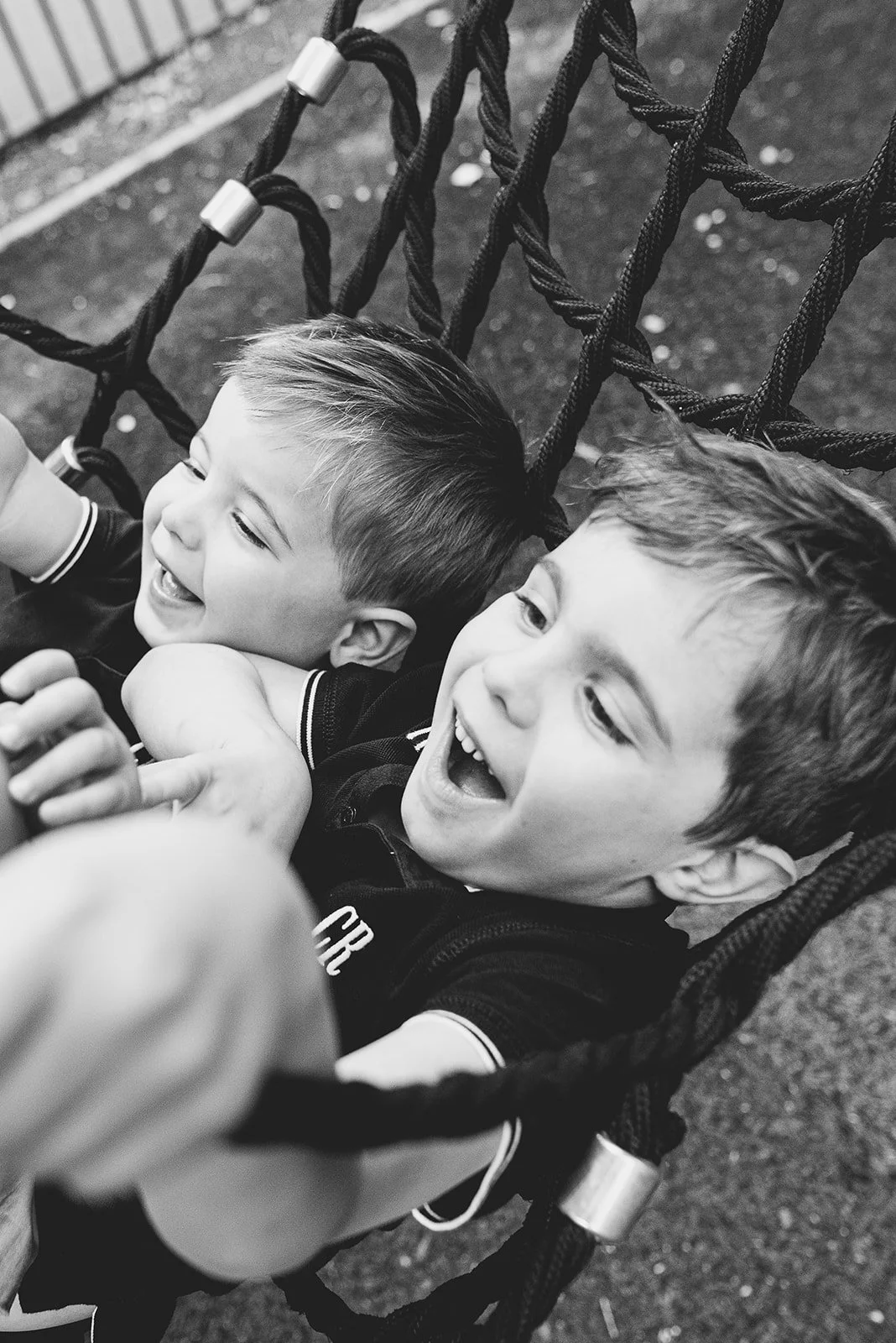 Blackheath family photoshoot, boys in swing in playground in Greenwich, South East London.