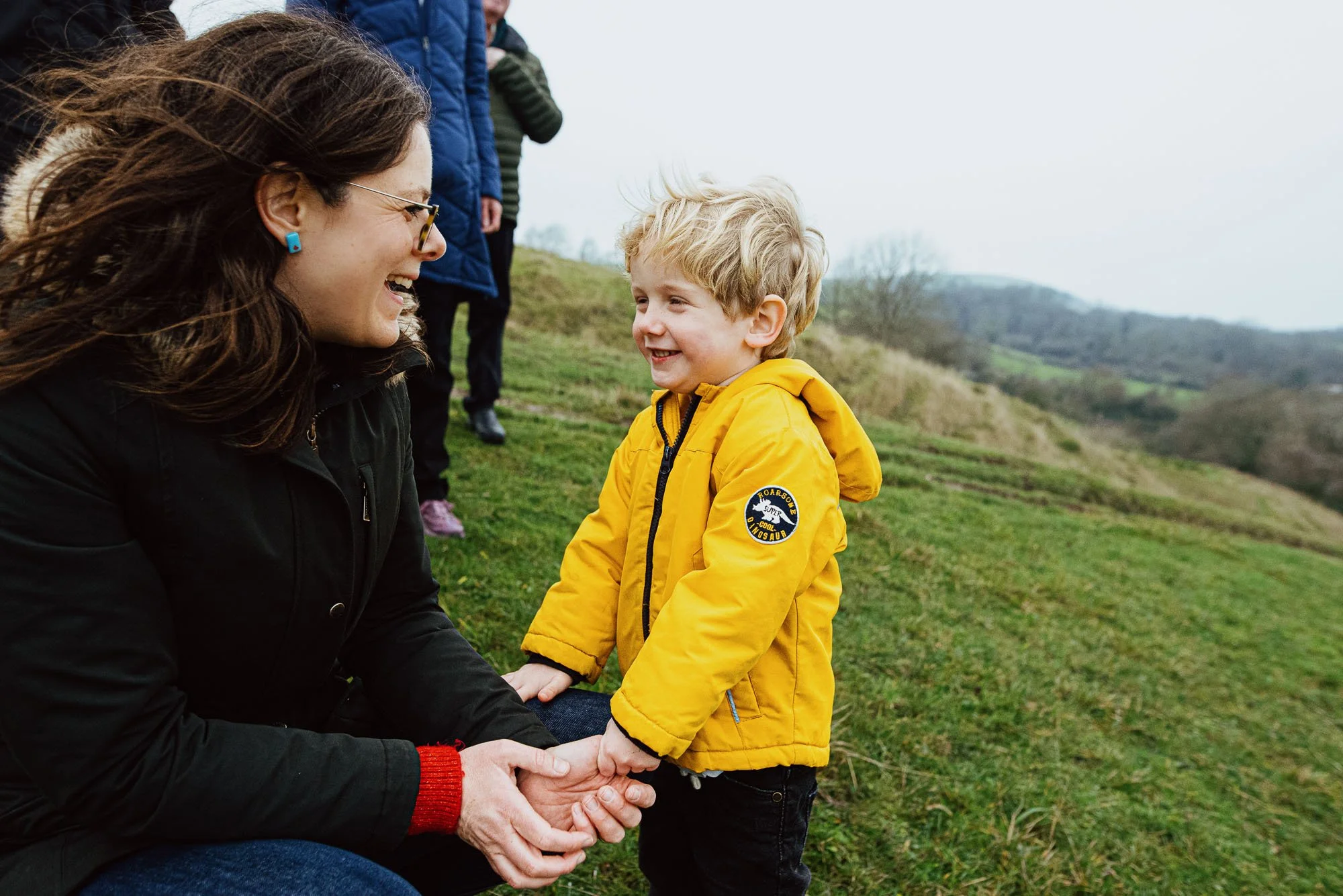 sussex-family-photographer-capturing-mother-holding-hands-sob-south-downs-unposed-lifestyle-family-photography-smiling-winter-day-hassocks-butchers-wood.jpg