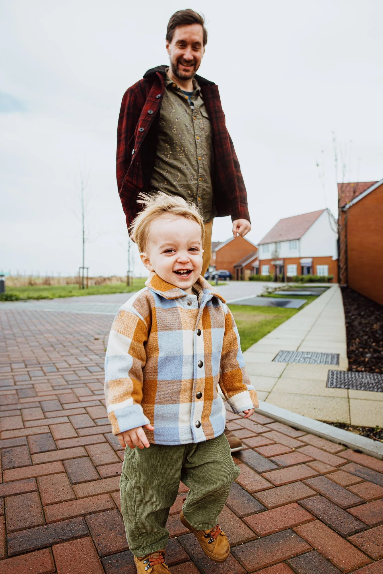 Sussex-familyphotographer-Lancing-family-photoshoot-at-home-natural-relaxed-candid-boy-and-dad-outside-houses.jpg