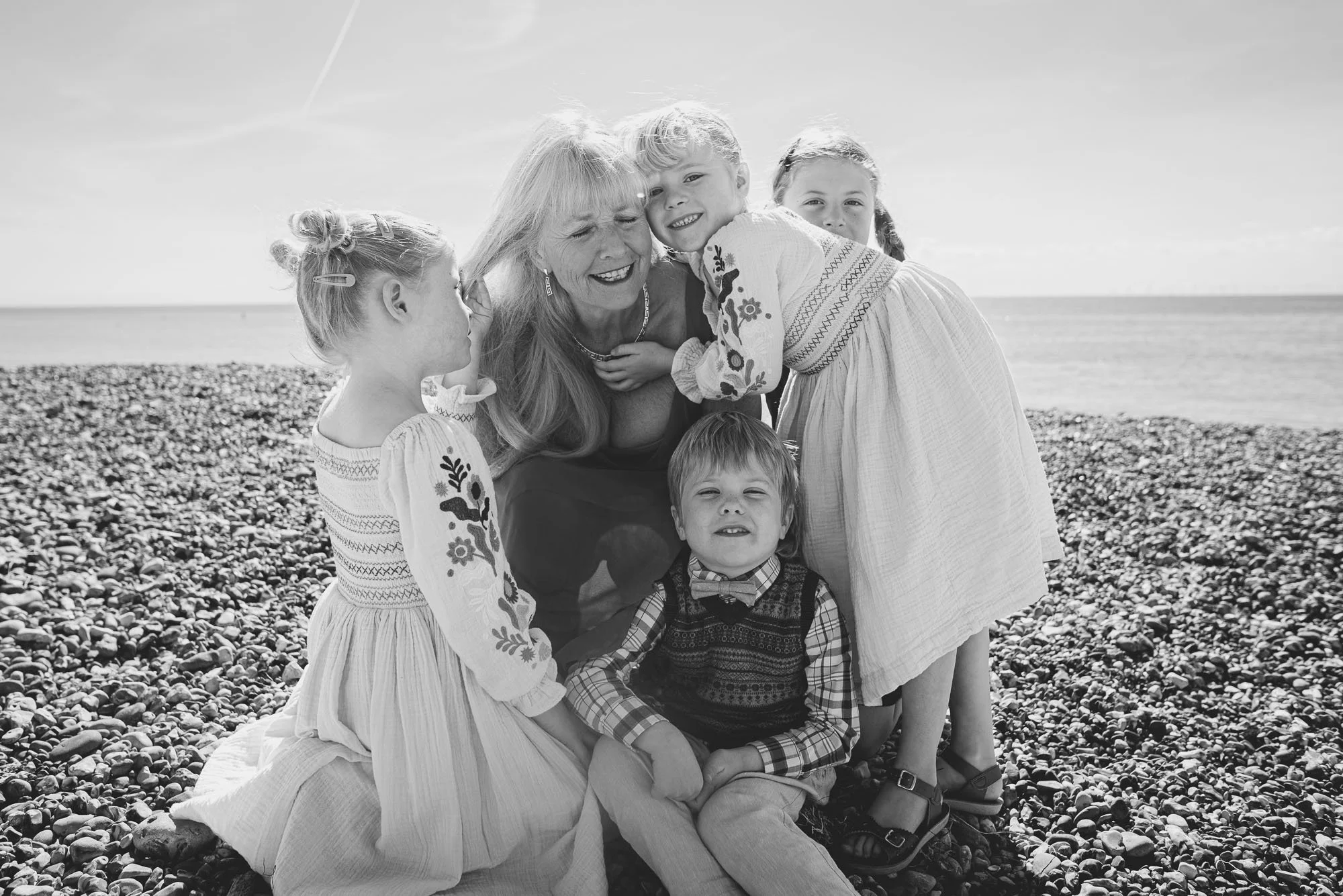 Worthing family photoshoot on the beach, portrait of grandmother and her grandchildren, natural, candid, lifestyle family photography in West Sussex.