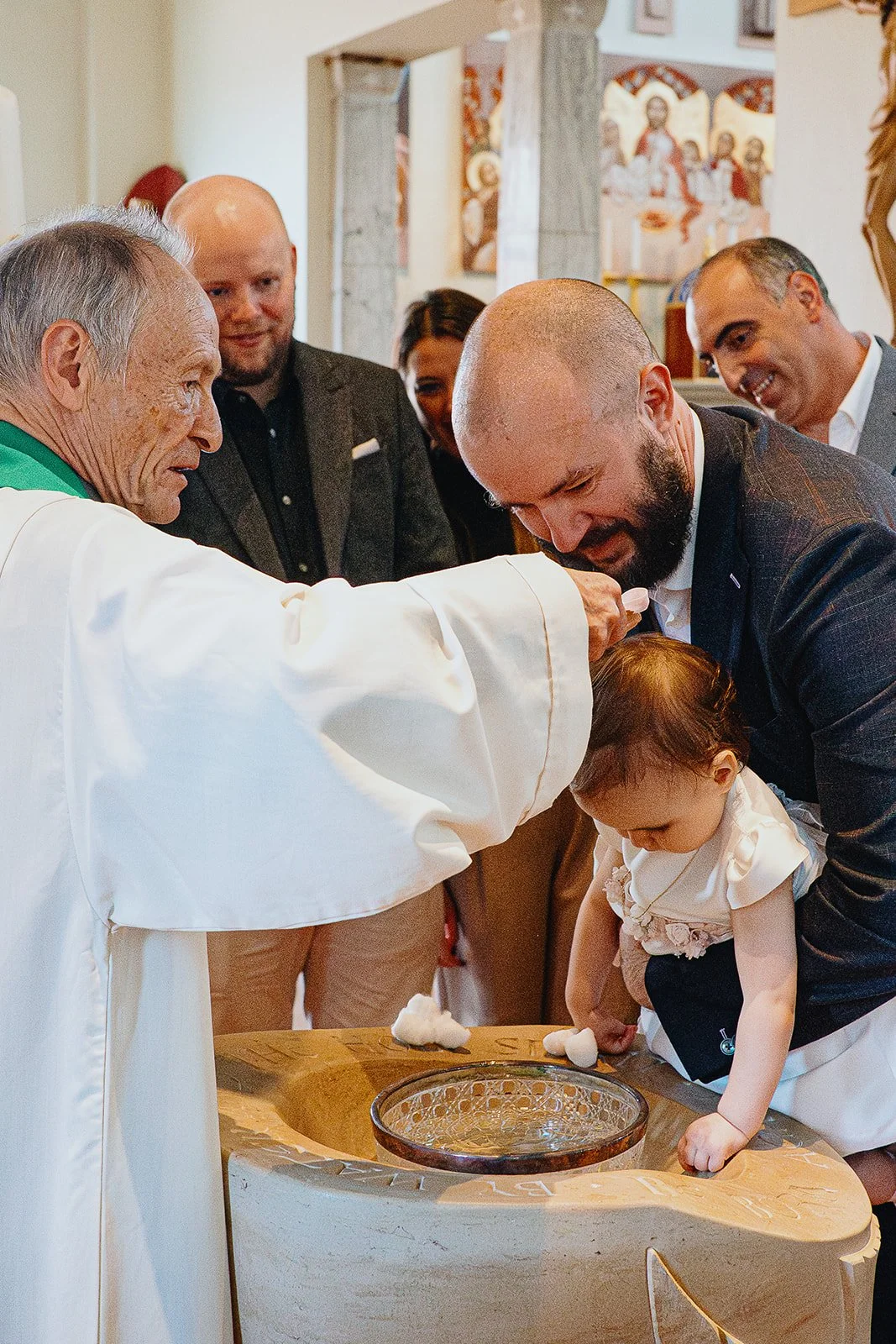 Girl getting christened in Chelsea Church in London. Natural documentary style christening and baptism photography in Chelsea.