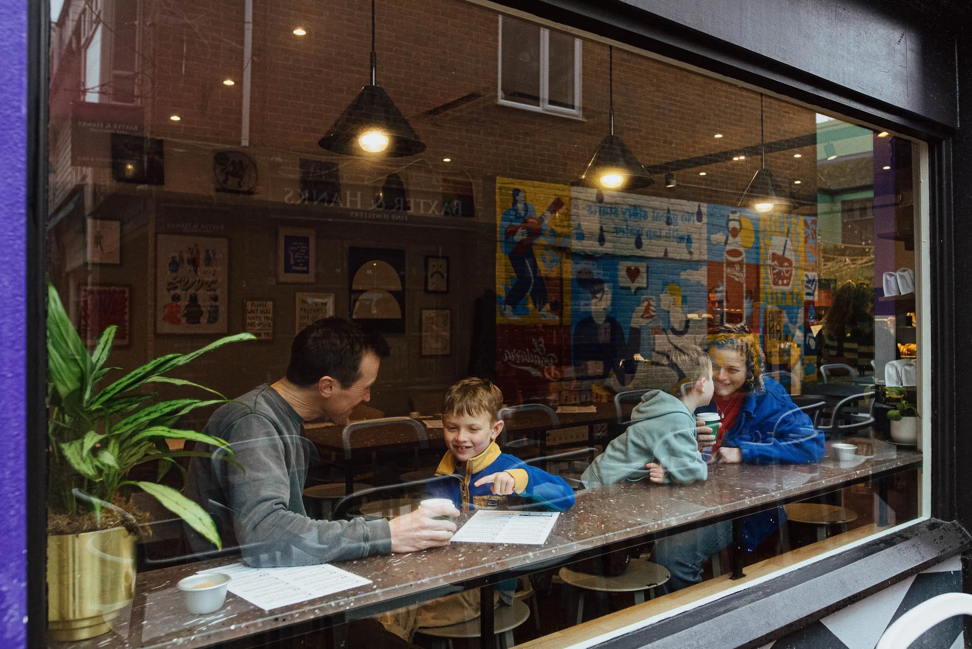 Brighton family portrait taken in the Lanes, central Brighton in a coffee shop, parents and two boys.