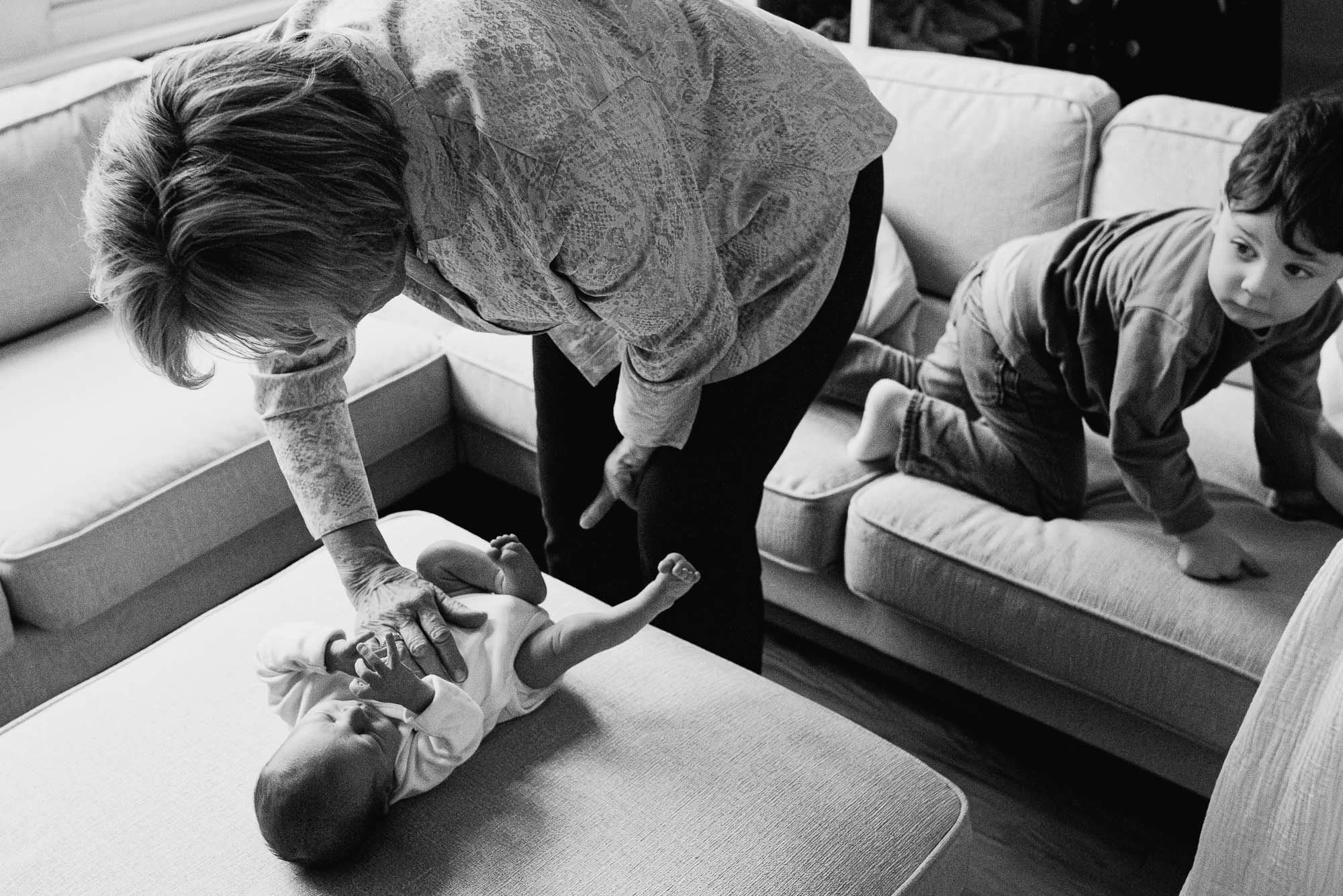 Surbiton at home newborn photo session, grandmother, baby boy and older sibling portrait in black and white.