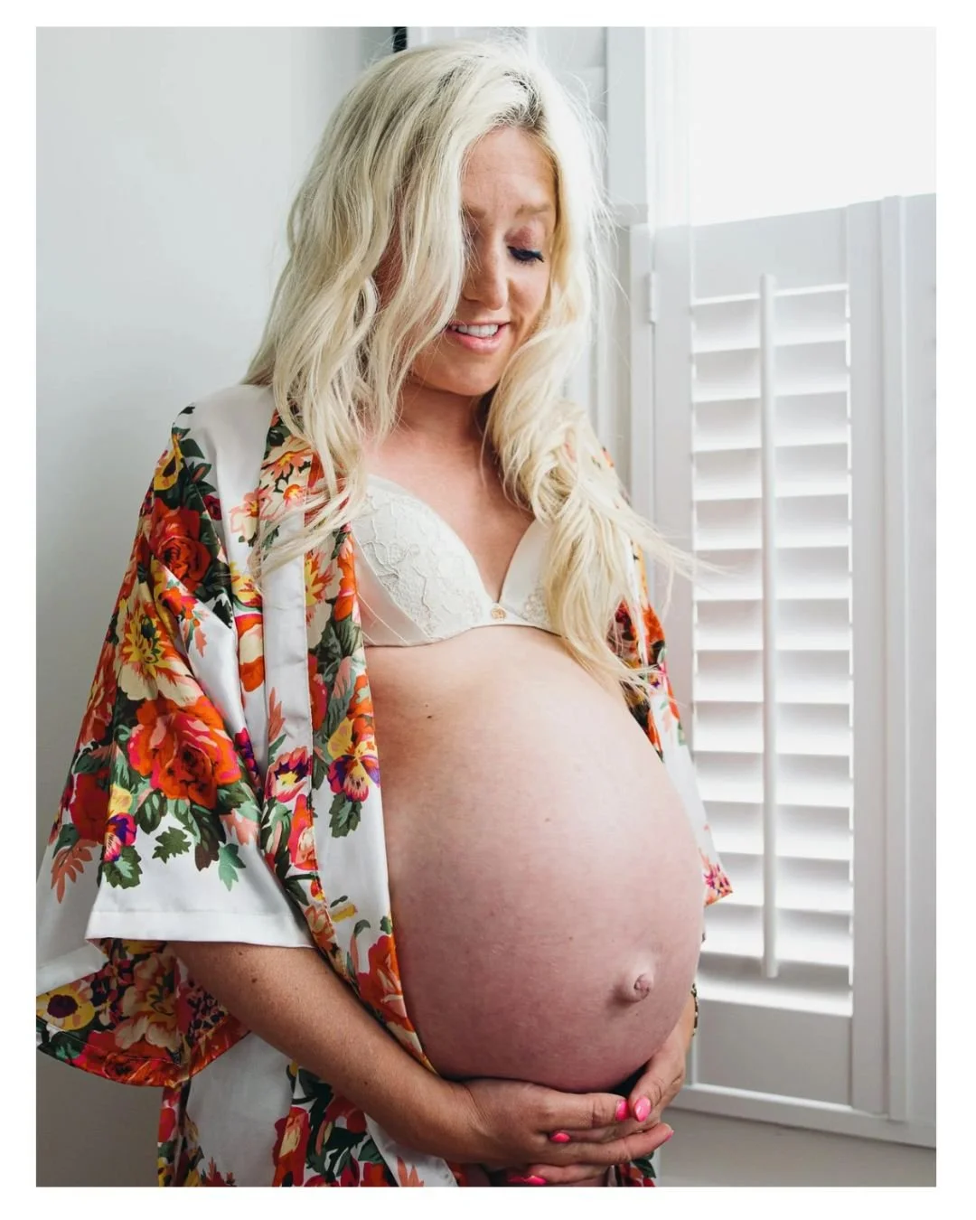 Wimbledon at home maternity photography, natural relaxed maternity portraits. Woman holding belly.