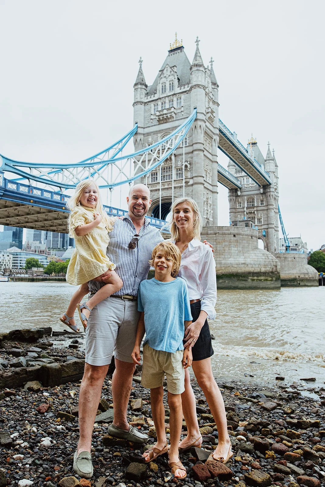 Family portrait near the Thames with Tower Bridge as an iconic London backdrop. Award-winning London vacation photography.