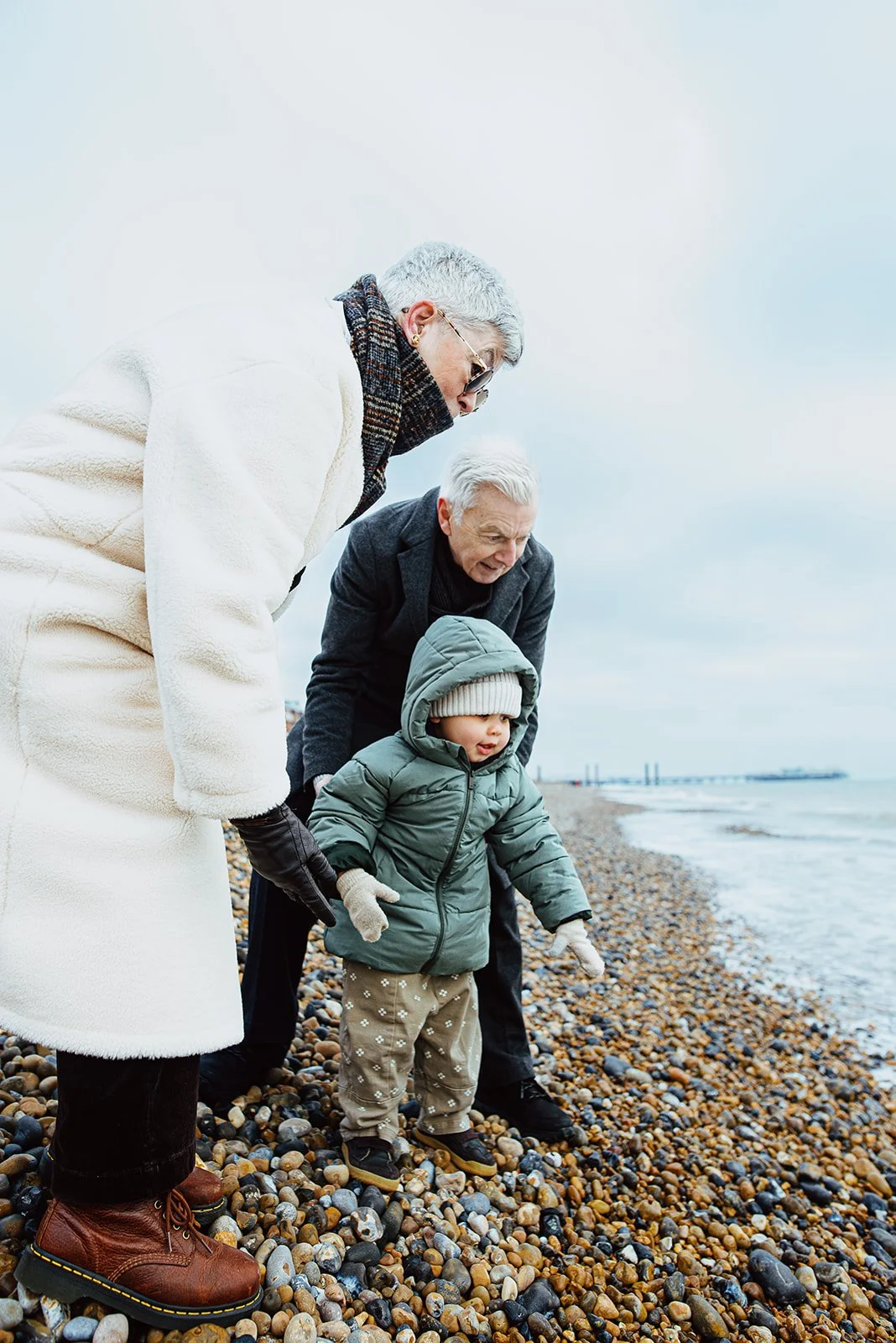 Grandparents with grandchild at Hove beach during Christmas family mini shoot.