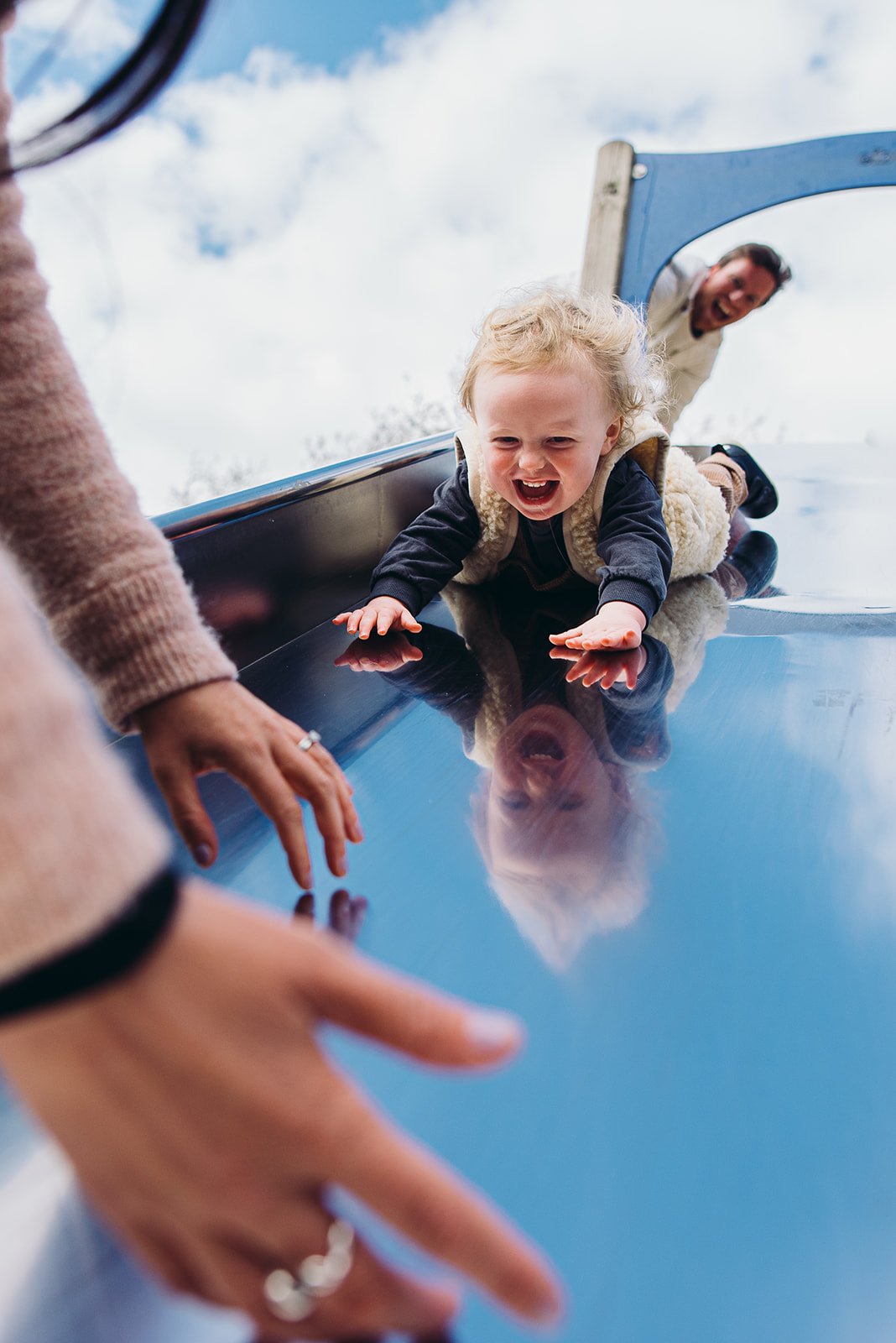 Hove family photographer capturing boy on the slide in Hove Park, East Sussex. Documentary-style family portraits in Brighton, Hove, Worthing, Chichester and across Sussex.