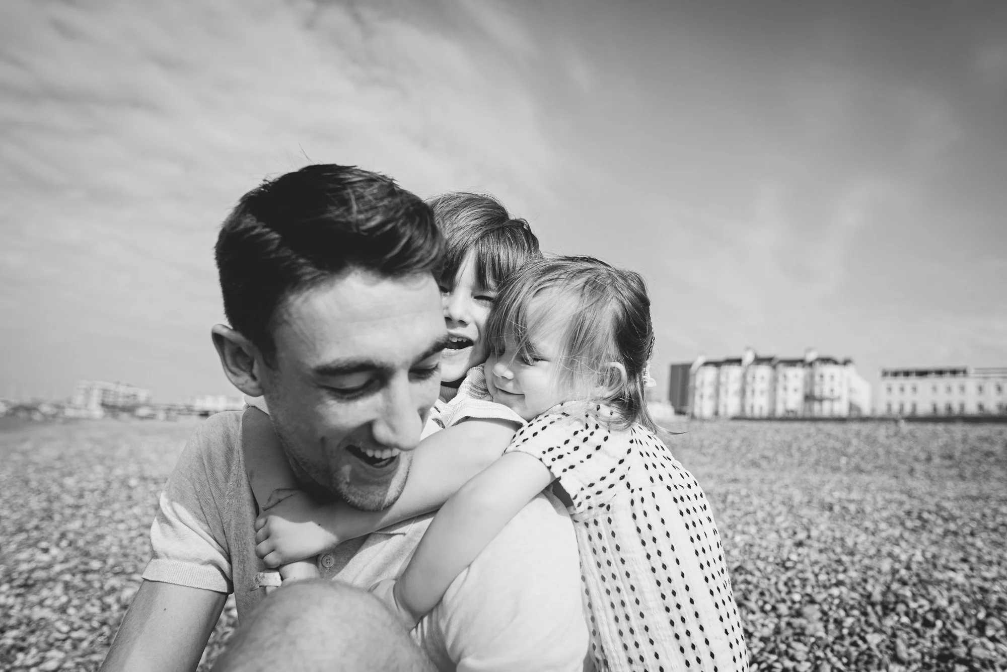 Brighton beach photoshoot, dad and his two children on the beach, natural, lifestyle family photography in Brighton, Hove and across Sussex.