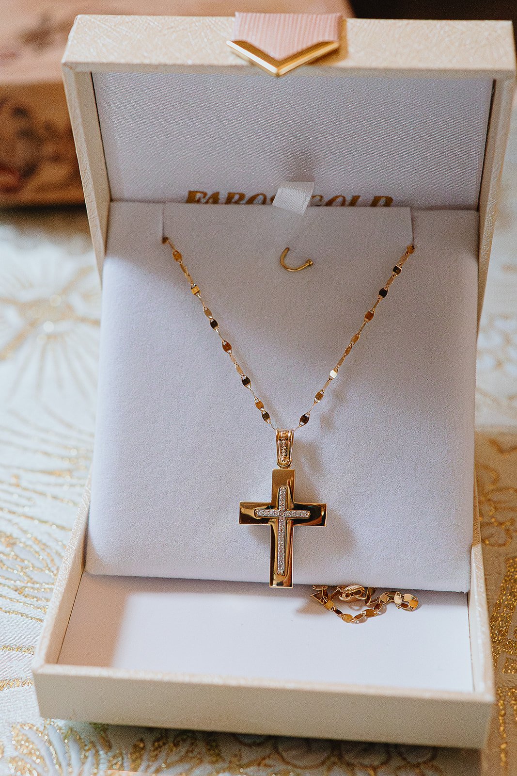 Chelsea Christening photographer capturing closeup shot of girl's christening necklace during Chelsea ceremony in Church.