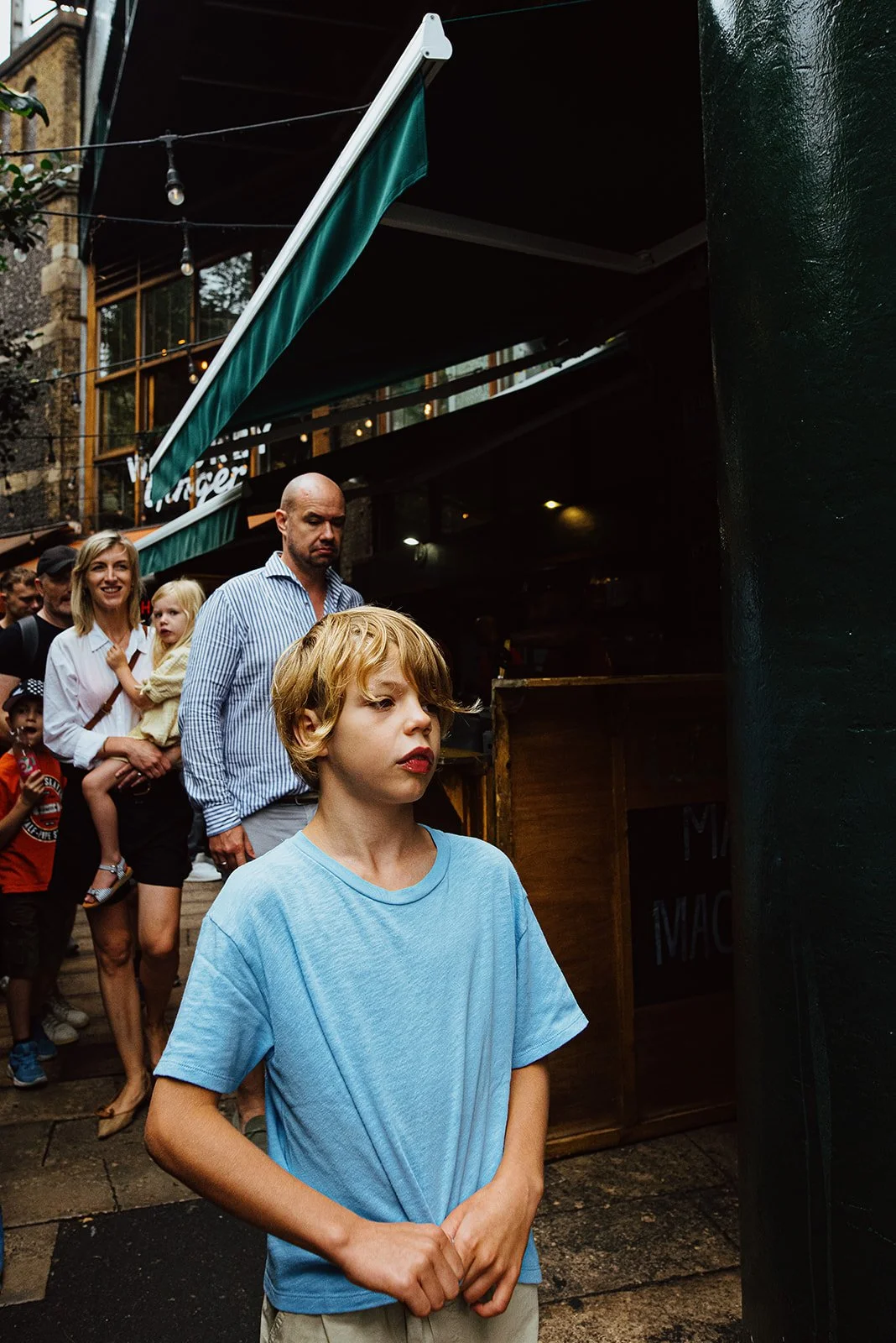Family walking along Borough Market looking for something to eat during their London holiday photo session. Belgian family on holiday in London.