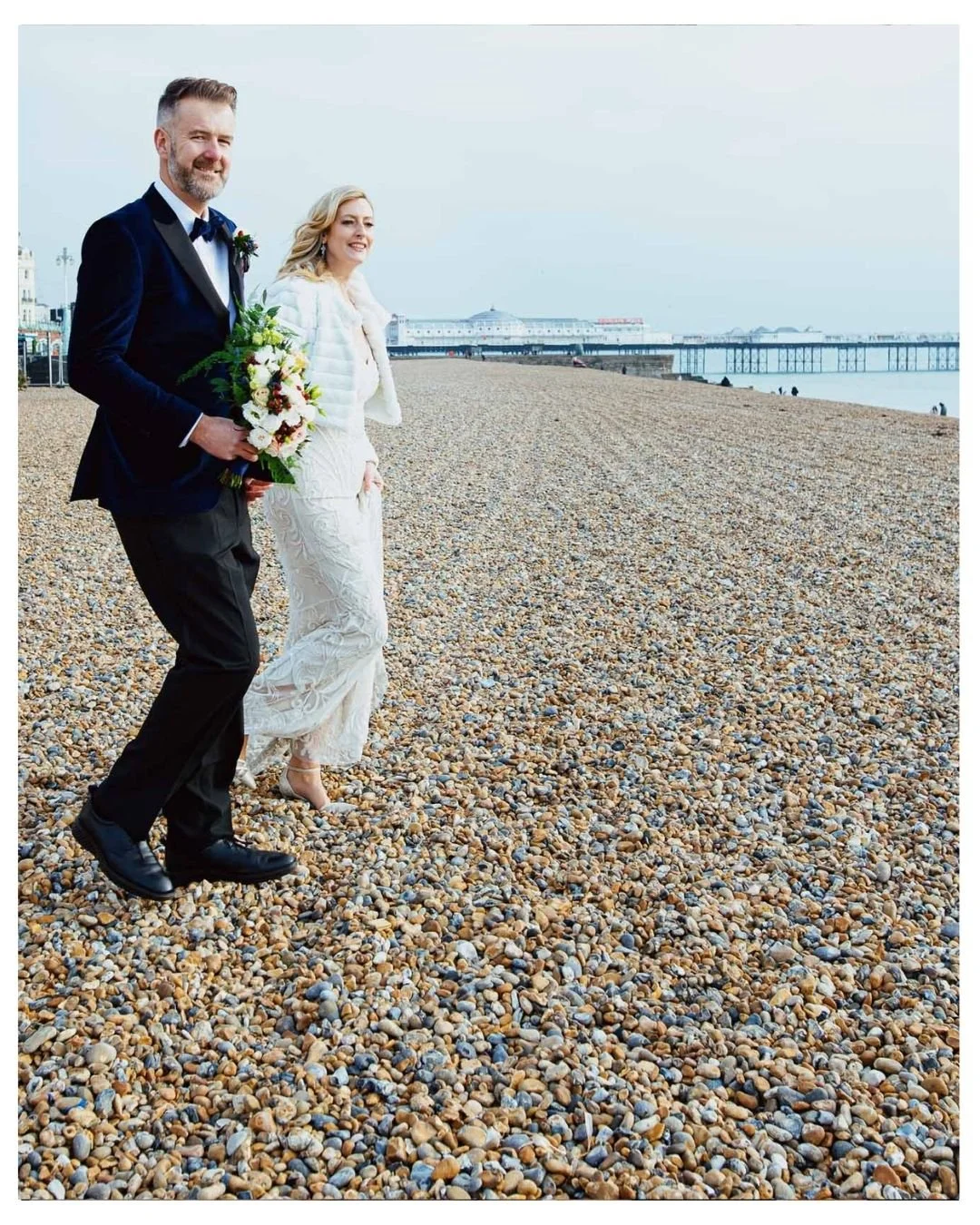 Brighton beach candid wedding portraits, couple hand in hand walking towards the sea. Natural and unposed wedding photos in Brighton and Hove for small weddings.