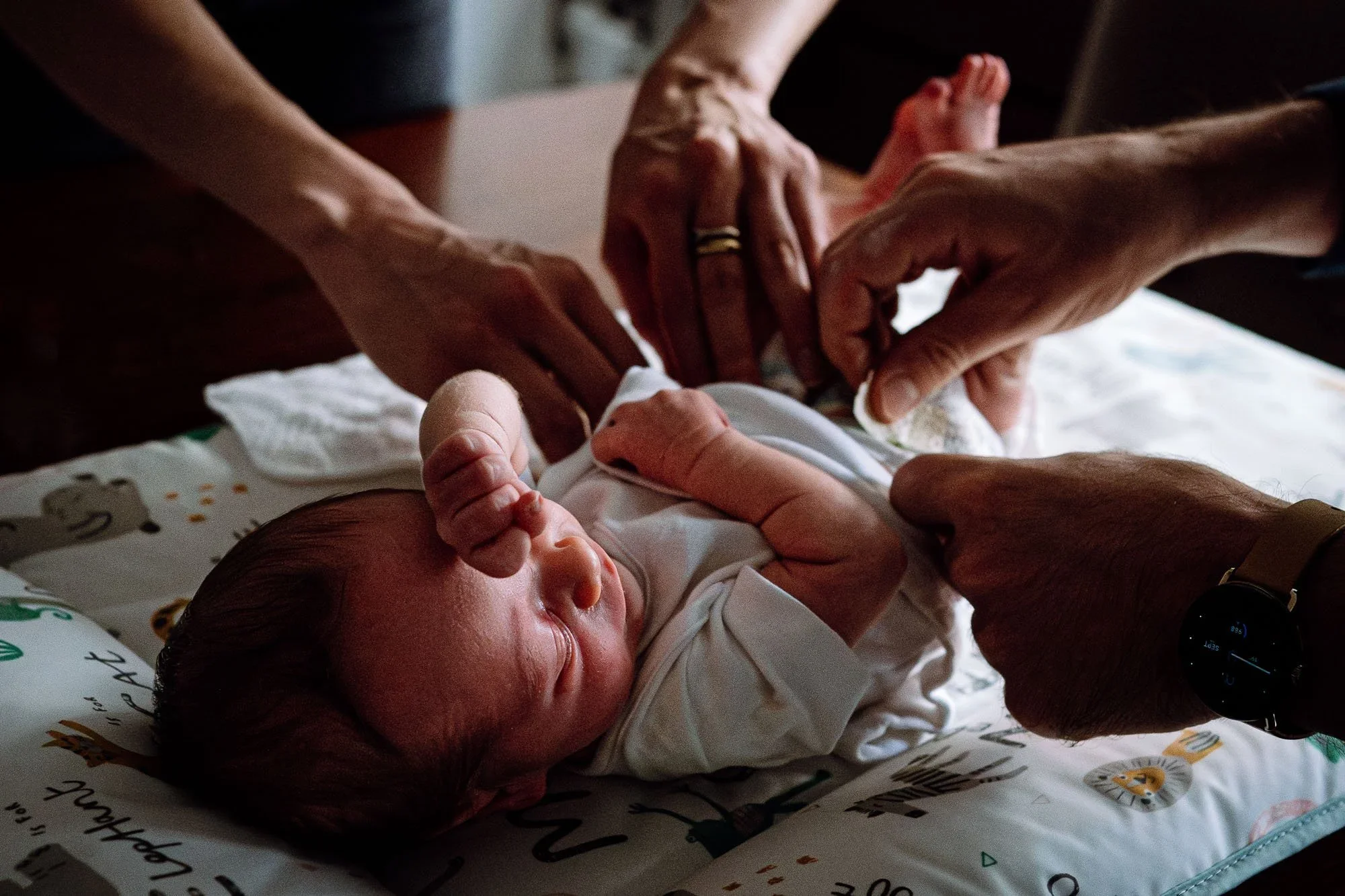 Battersea newborn photographer capturing little baby boy on changing mat ready for his nappy change. Natural newborn baby photography in South London.
