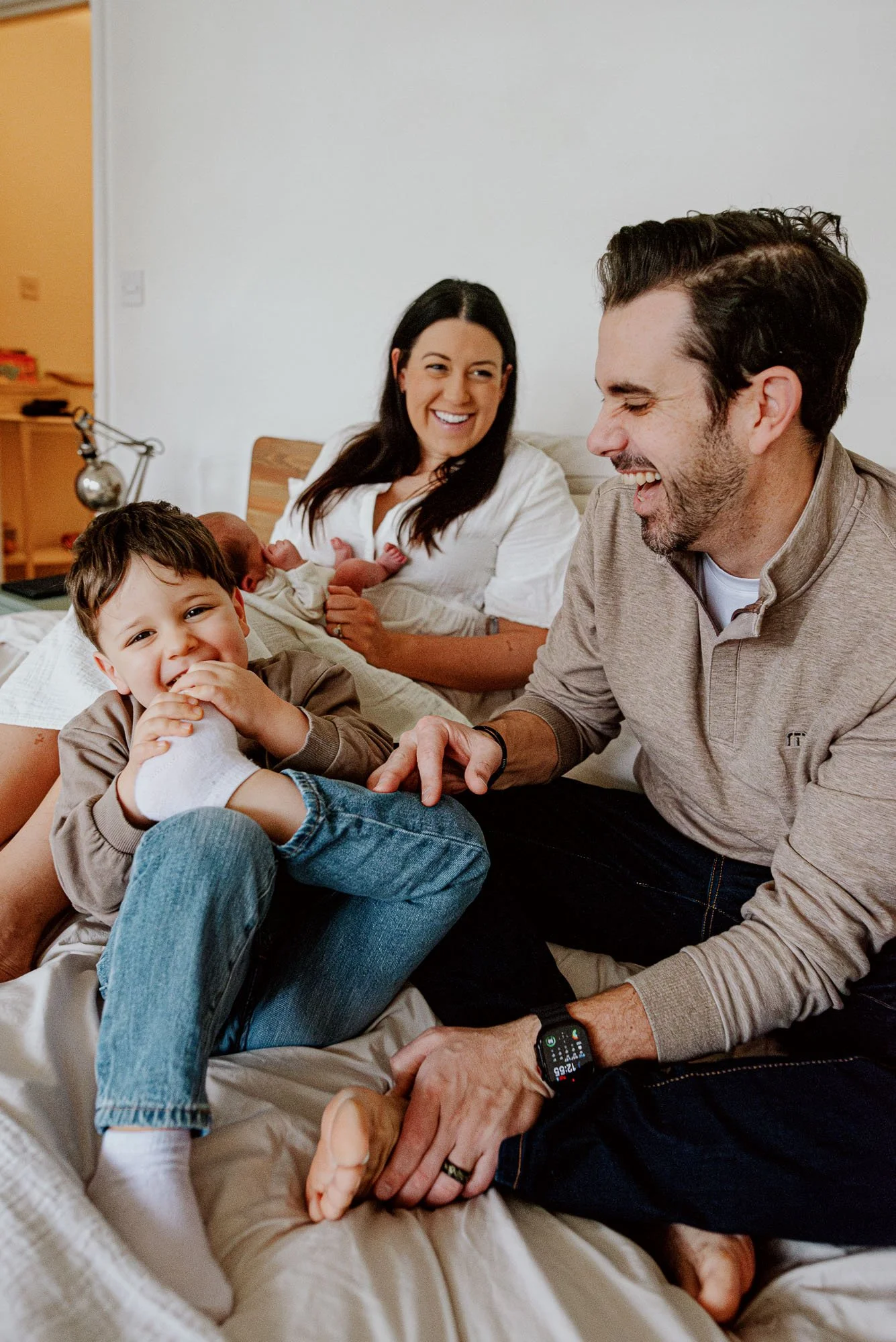 Surbiton newborn photoshoot at home, South London newborn baby photography natural, relaxed and unposed. Family portrait of parents, baby boy and sibling.
