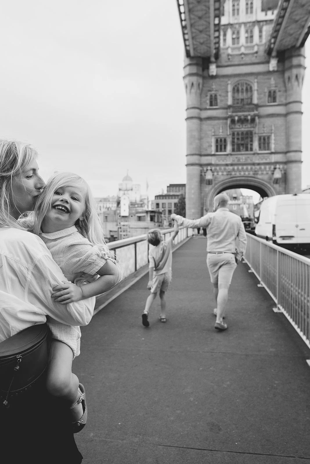 Best London vacation photographer capturing family walking along the Tower Bridge during their London family photoshoot.