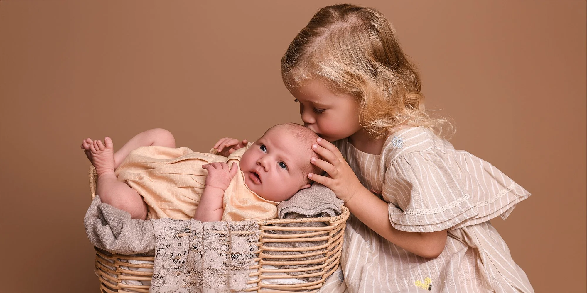 Big sister with her little sister in a newborn photoshoot