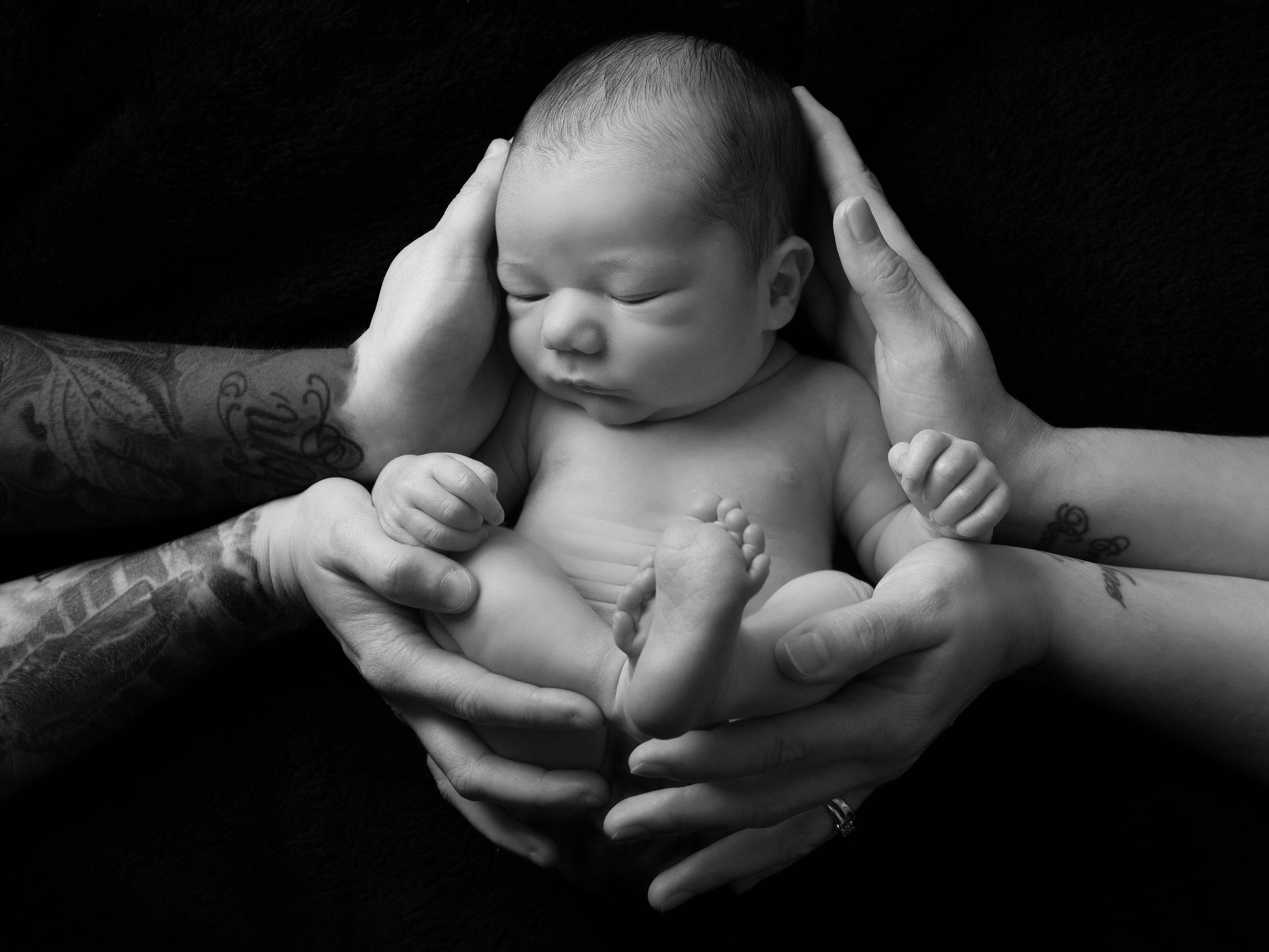 Newborn in parents hands in newborn photo Warwickshire