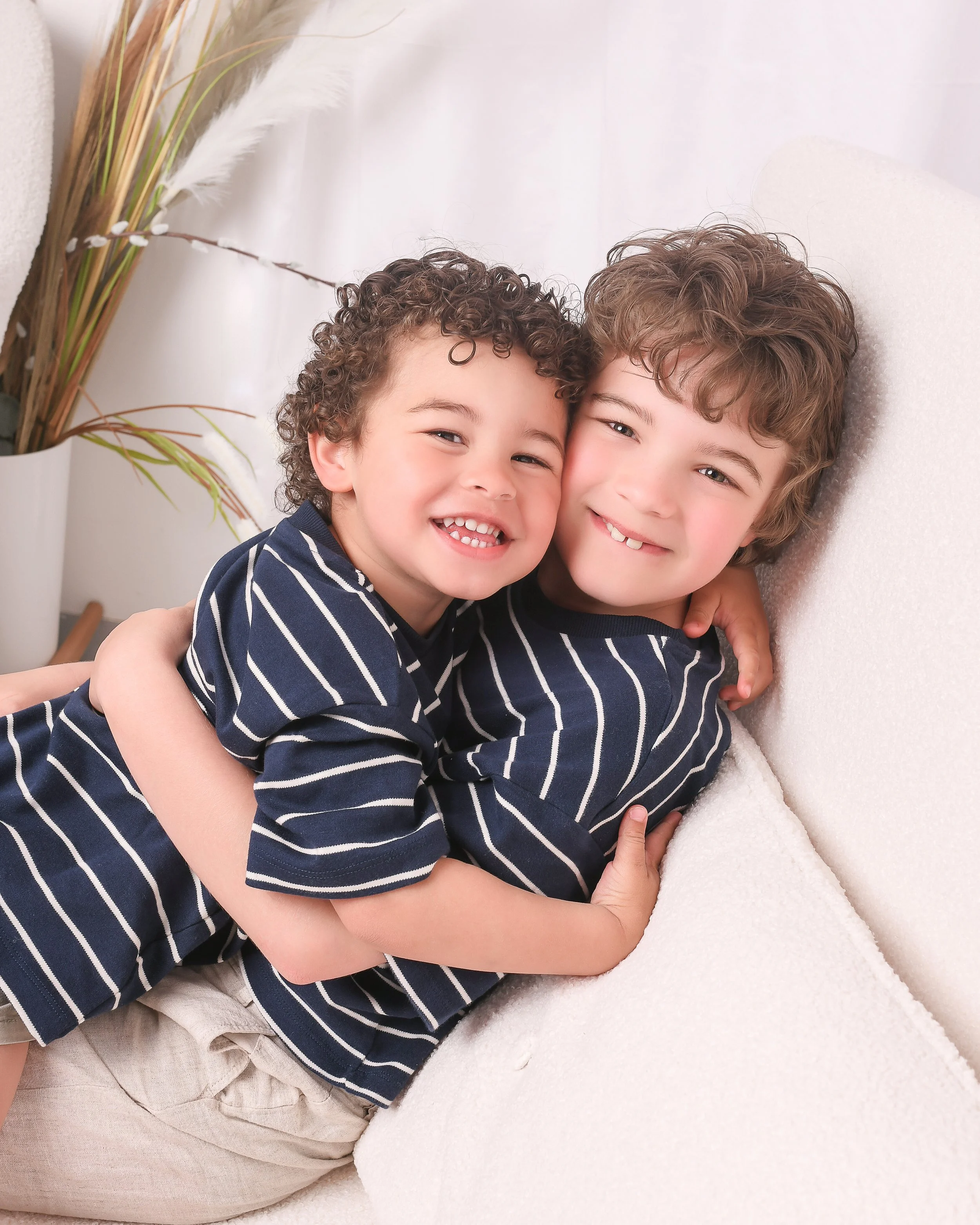 Brothers hug in a happy photo in a Warwickshire based studio