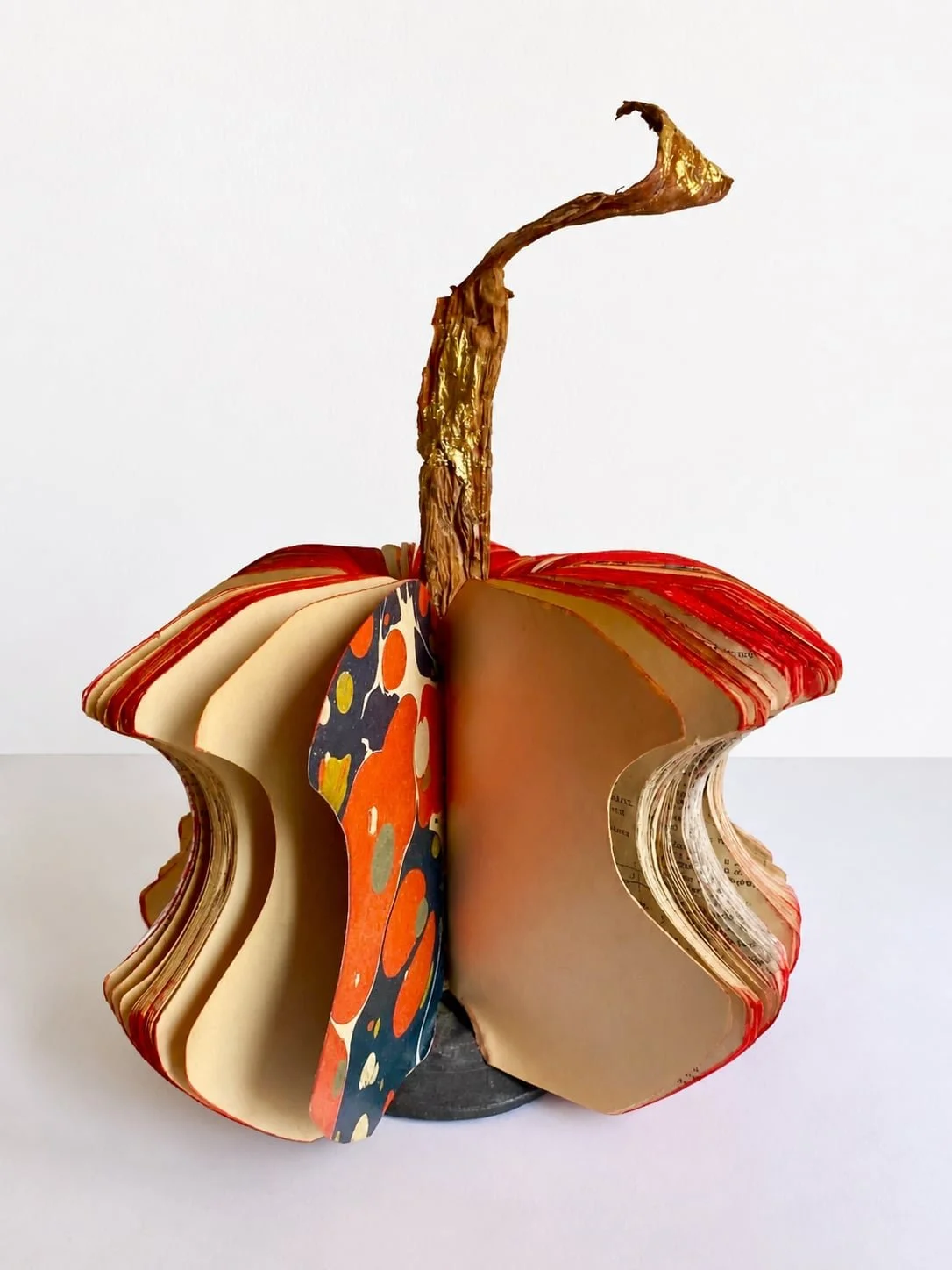 The Apple Squircle
2026
Handcrafted and altered geometry books from the artist’s family collection, pastel powder, marbled papers, wood, natural leaf, and gold leaf.
50 cm high × 40 cm diameter.