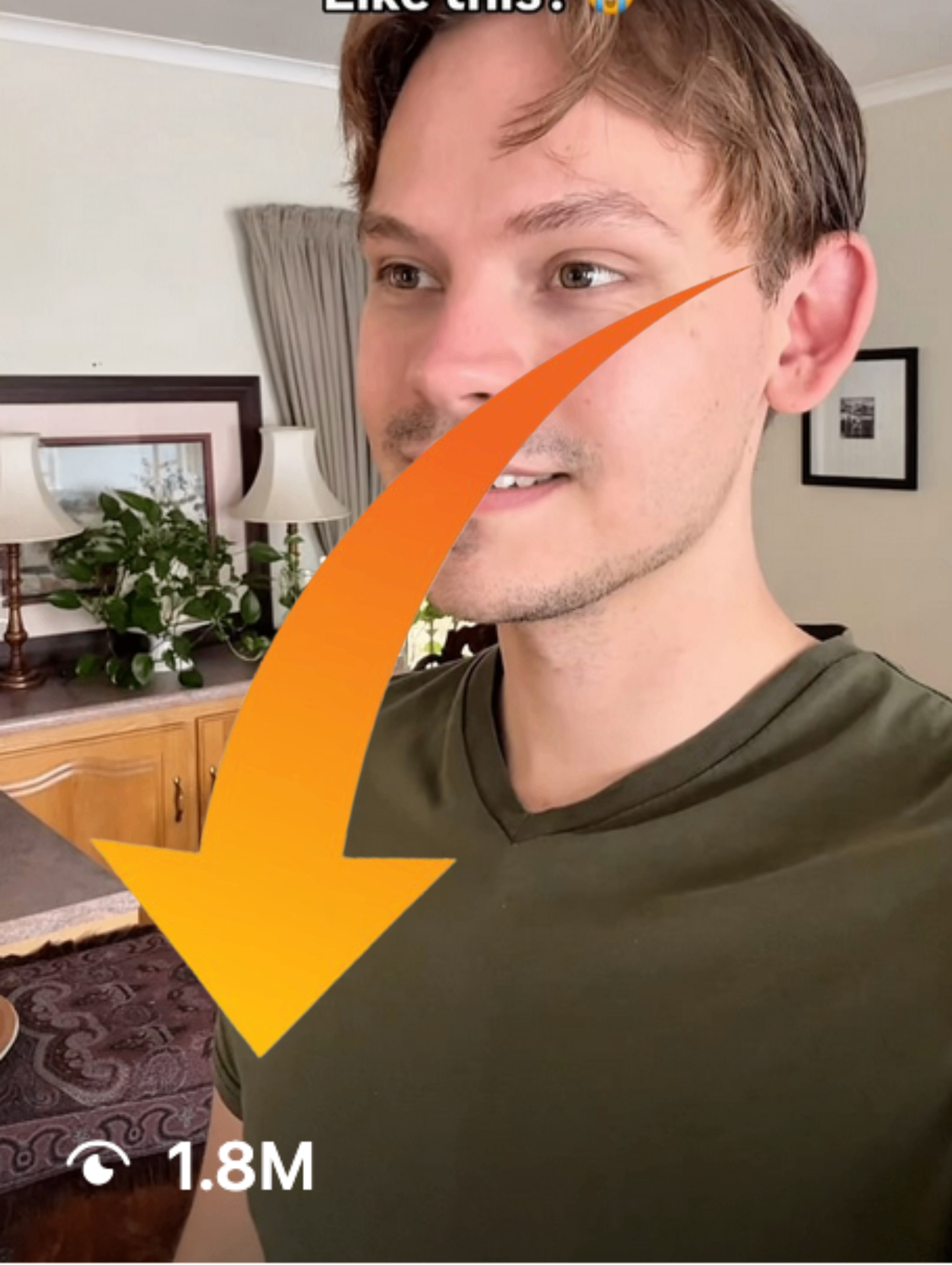 Ruben Uitenweerde. 7rend CEO. Close-up of a young man with light brown hair and slight facial hair, wearing an olive green T-shirt, smiling slightly in a living room with beige walls, framed pictures, a lamp, and a wooden cabinet