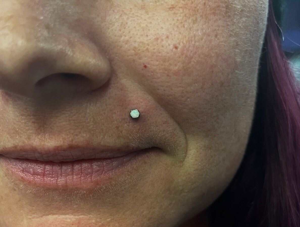 Monroe piercing done with a White Opal x titanium bezel top 🫧

Rachel&rsquo;s available this weekend for piercings Friday-Sunday 🤗
@pokes_by_ray 
.
.
.
.
#monroe #monroepiercing #opal #piercing #pierced #facepiercings #lippiercing #gta #brampton