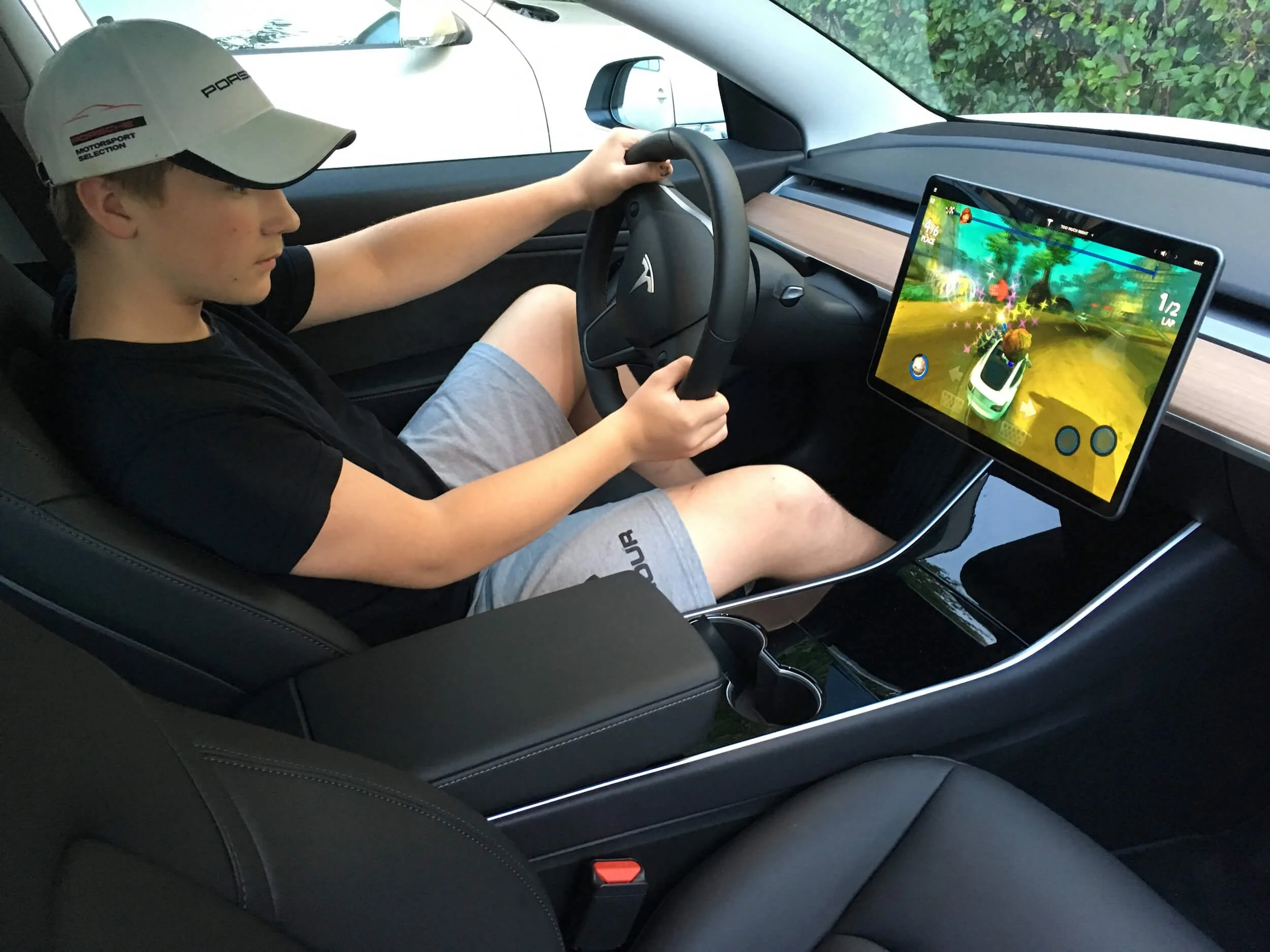  2020-talets definition av körglädje –&nbsp;att sitta i en parkerad bil och köra bilspel? För en junior utan körkort är det i alla fall ett sätt att få smaka på den goda men ännu förbjudna frukten.  Tesla Model 3 , som jag testade för TT Nyhetsbyrån.