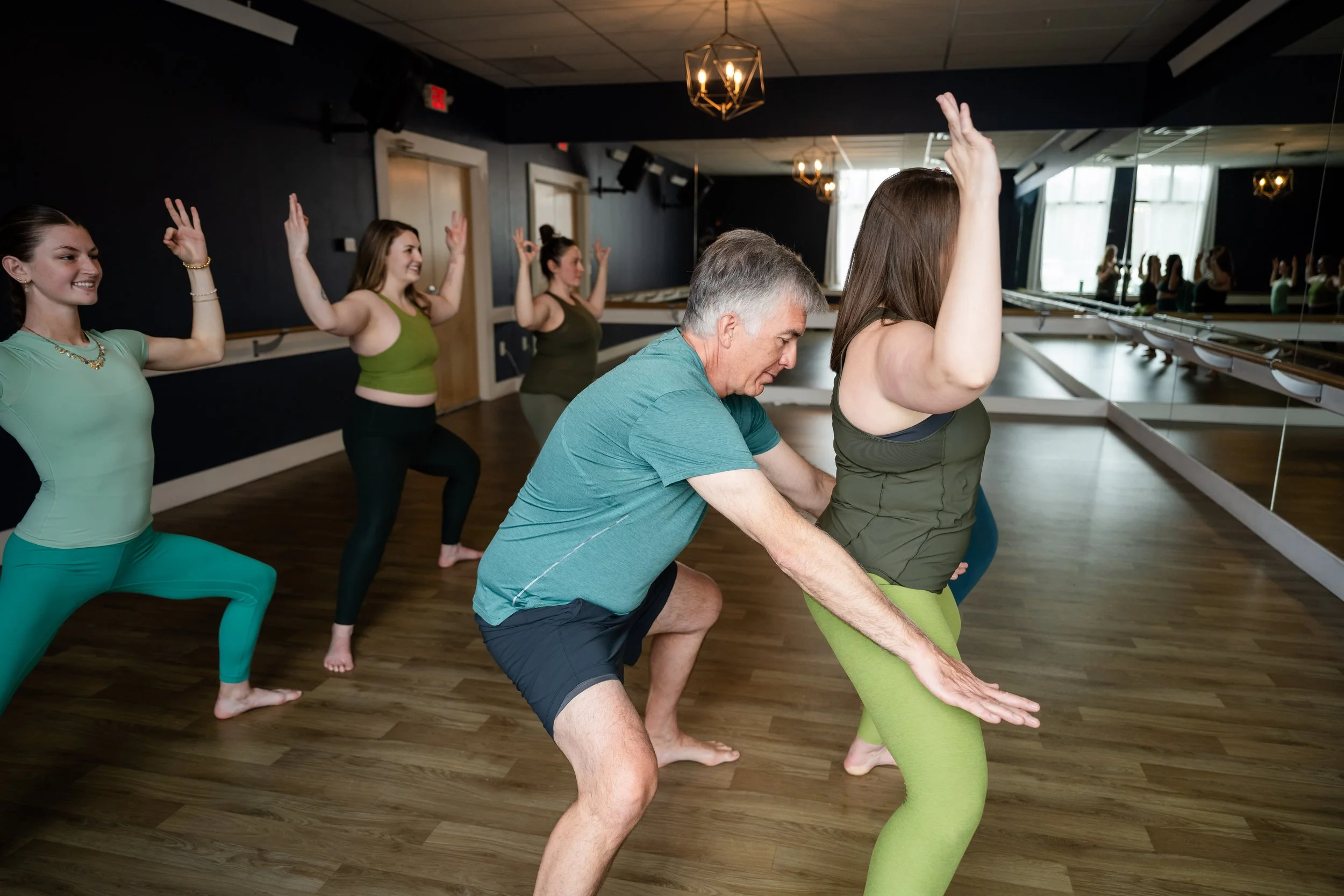hot yoga students in goddess pose