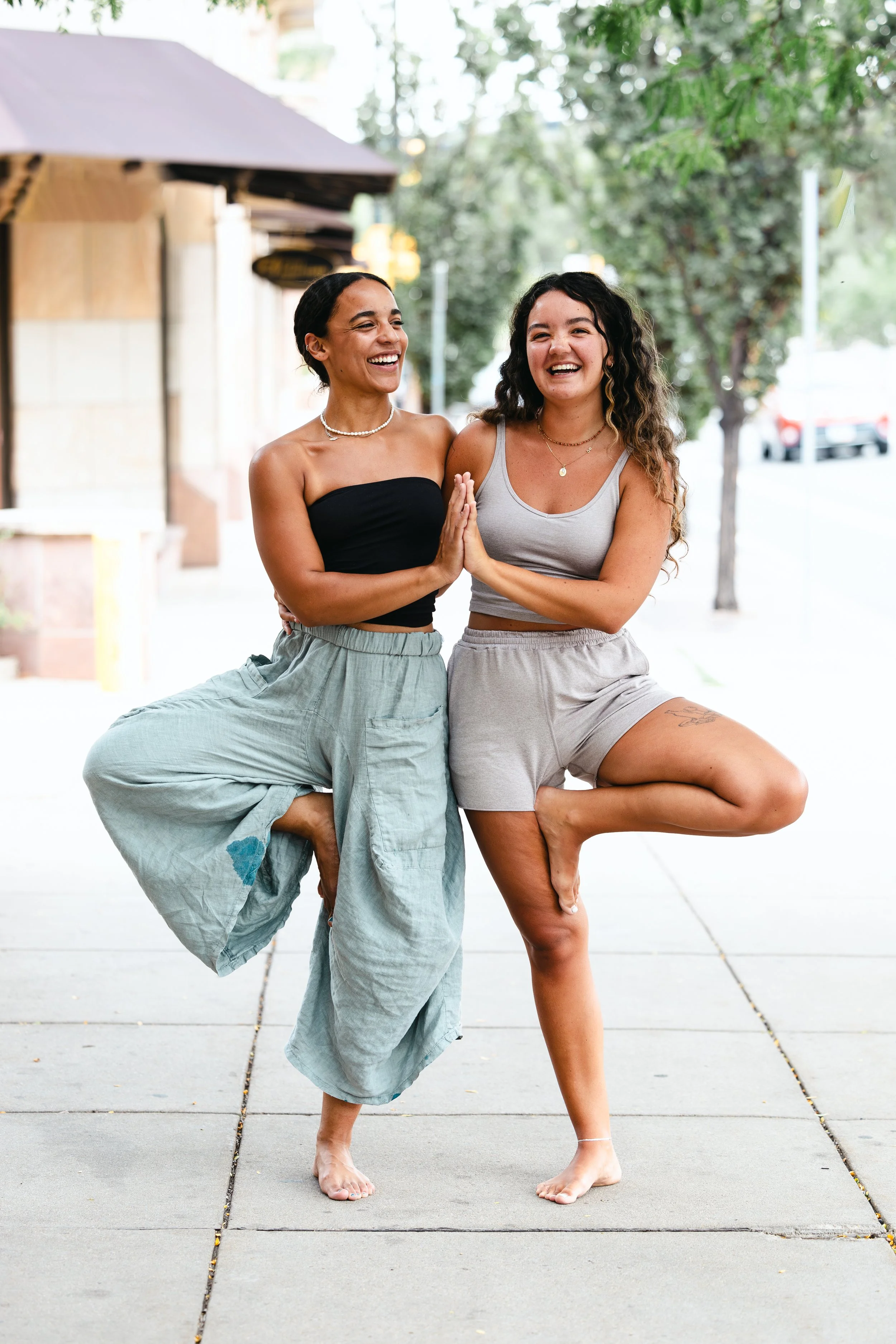 Two girls in tree pose outside the studio