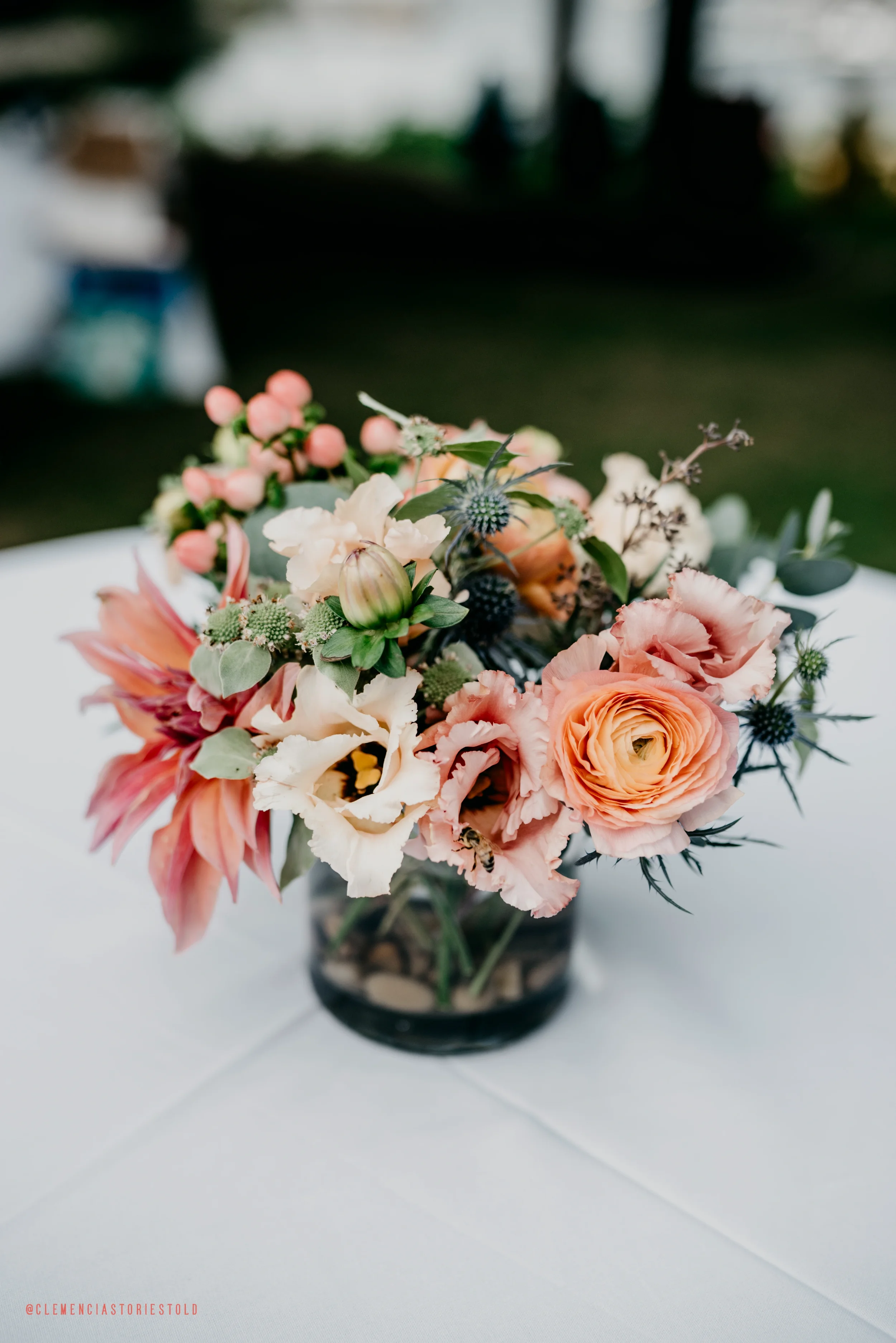 A colorful flower arrangement in a glass vase on a white table.