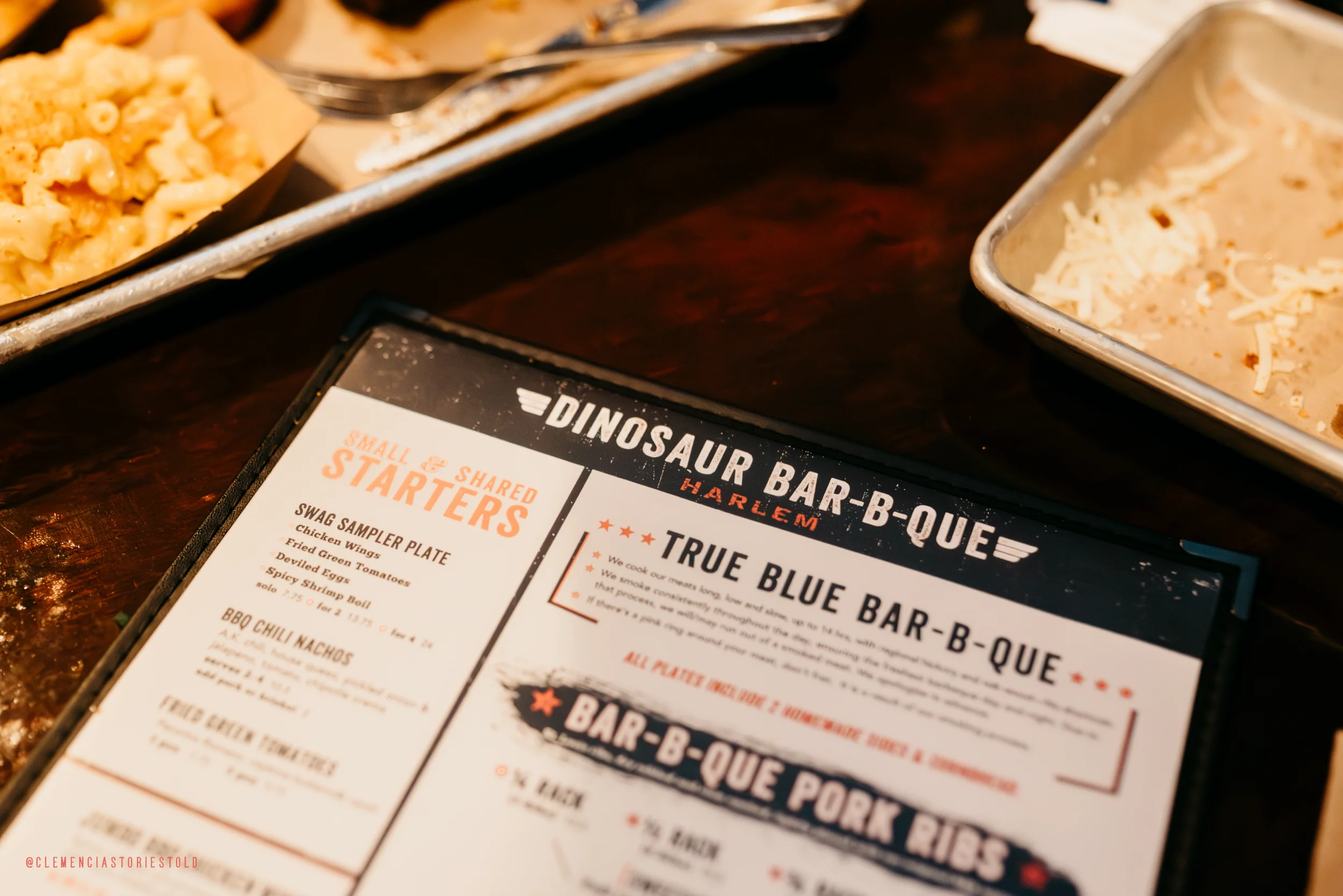 Dinosaur Bar-B-Que menu on a table with some food in the background.