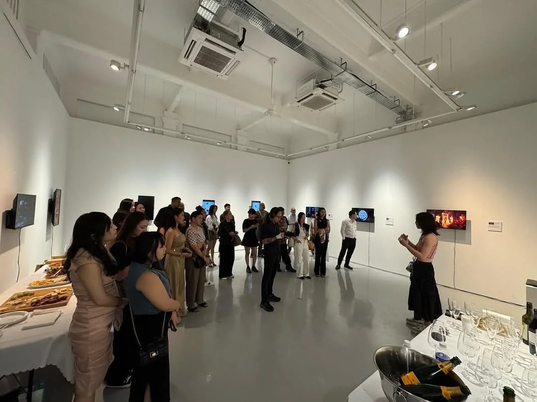 Shavonne Wong giving an artist talk at her solo exhibition “EVA” at The Columns Gallery, Singapore, surrounded by visitors engaging with digital and interactive works.