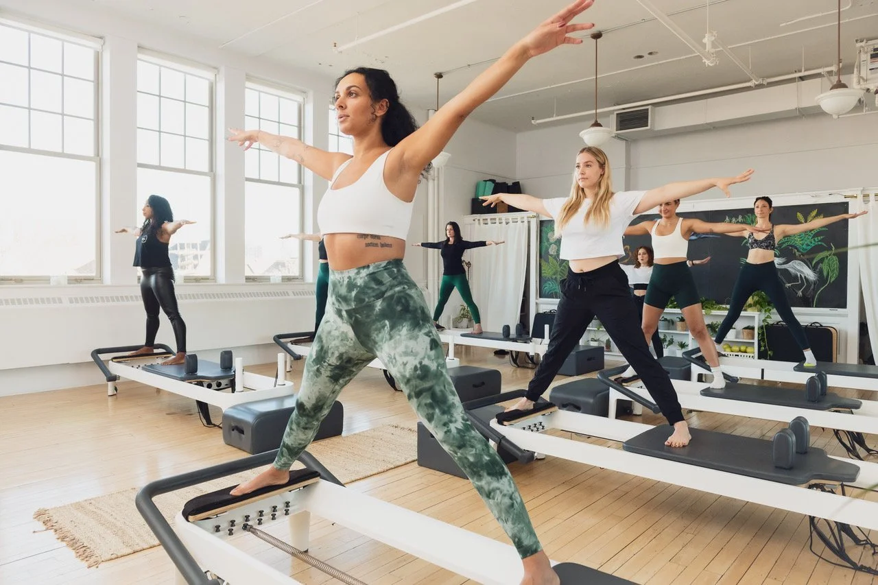 Pilates students in a reformer session at Muse Movement