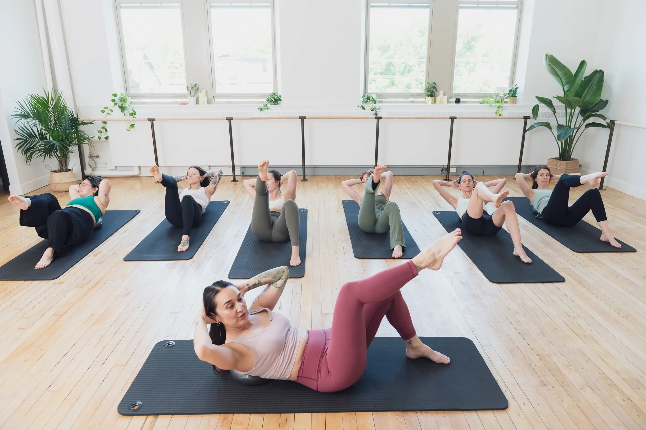 Pilates Instructor leading a mat Pilates class in a Toronto Pilates studio